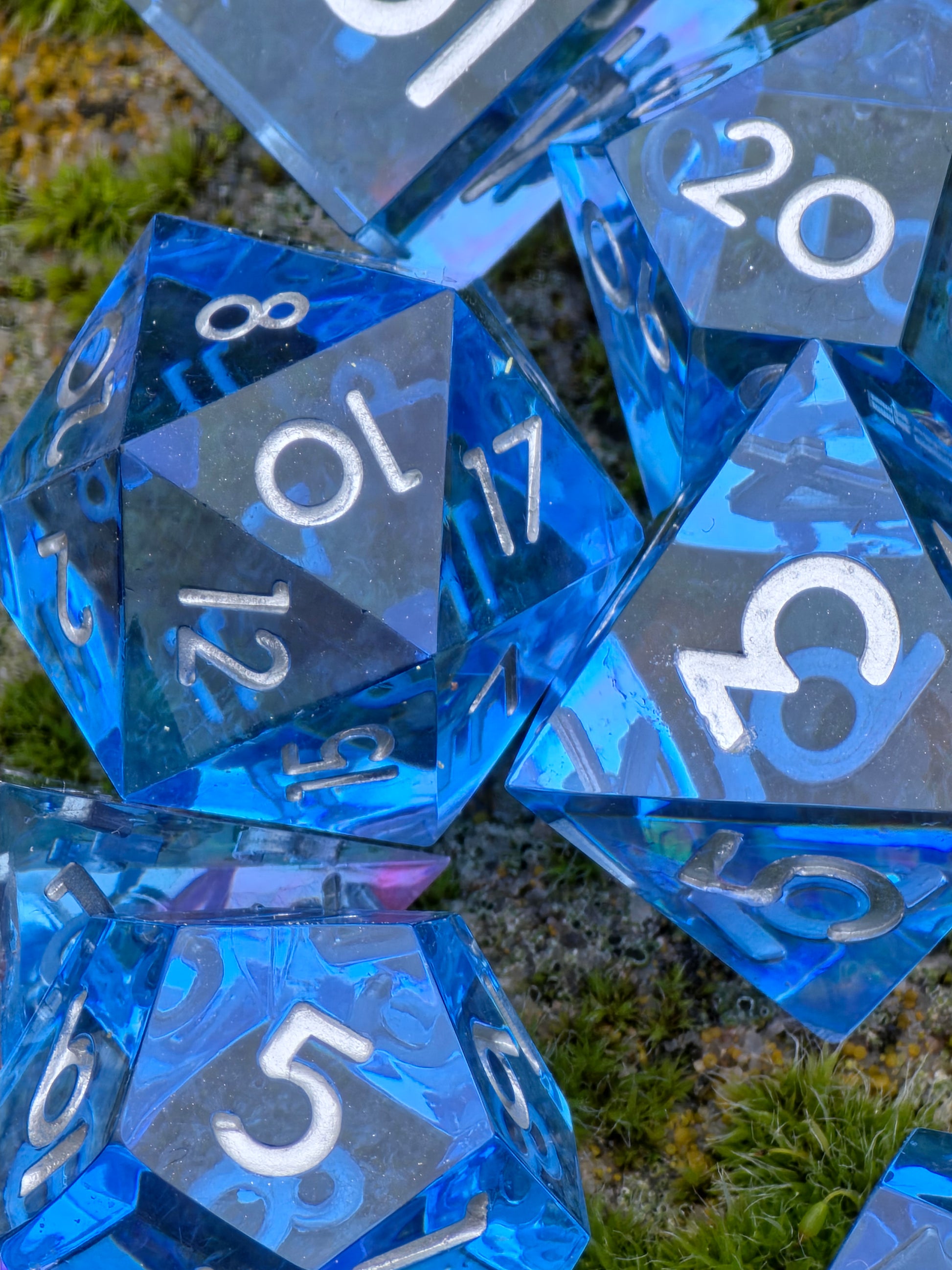 Nahaufnahme der Tiefenwirkung des „Abyss of the Sapphire Tide“ Würfelsets, erinnert an dunkles Ozeanwasser.  
Close-up showing the depth of the “Abyss of the Sapphire Tide” dice set, reminiscent of deep ocean waters.
