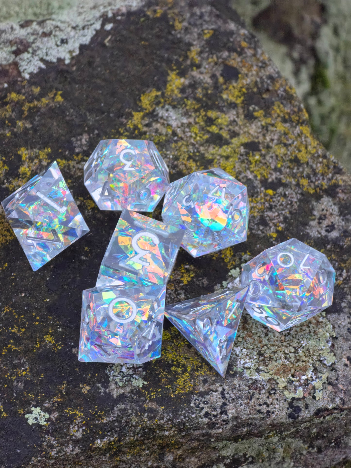 D20 im „Aether Shards“ Set, mit holografischen Fragmenten und silbernen Zahlen, klar und glänzend. 
D20 in the “Aether Shards” set, with holographic fragments and silver numbers, clear and glossy.