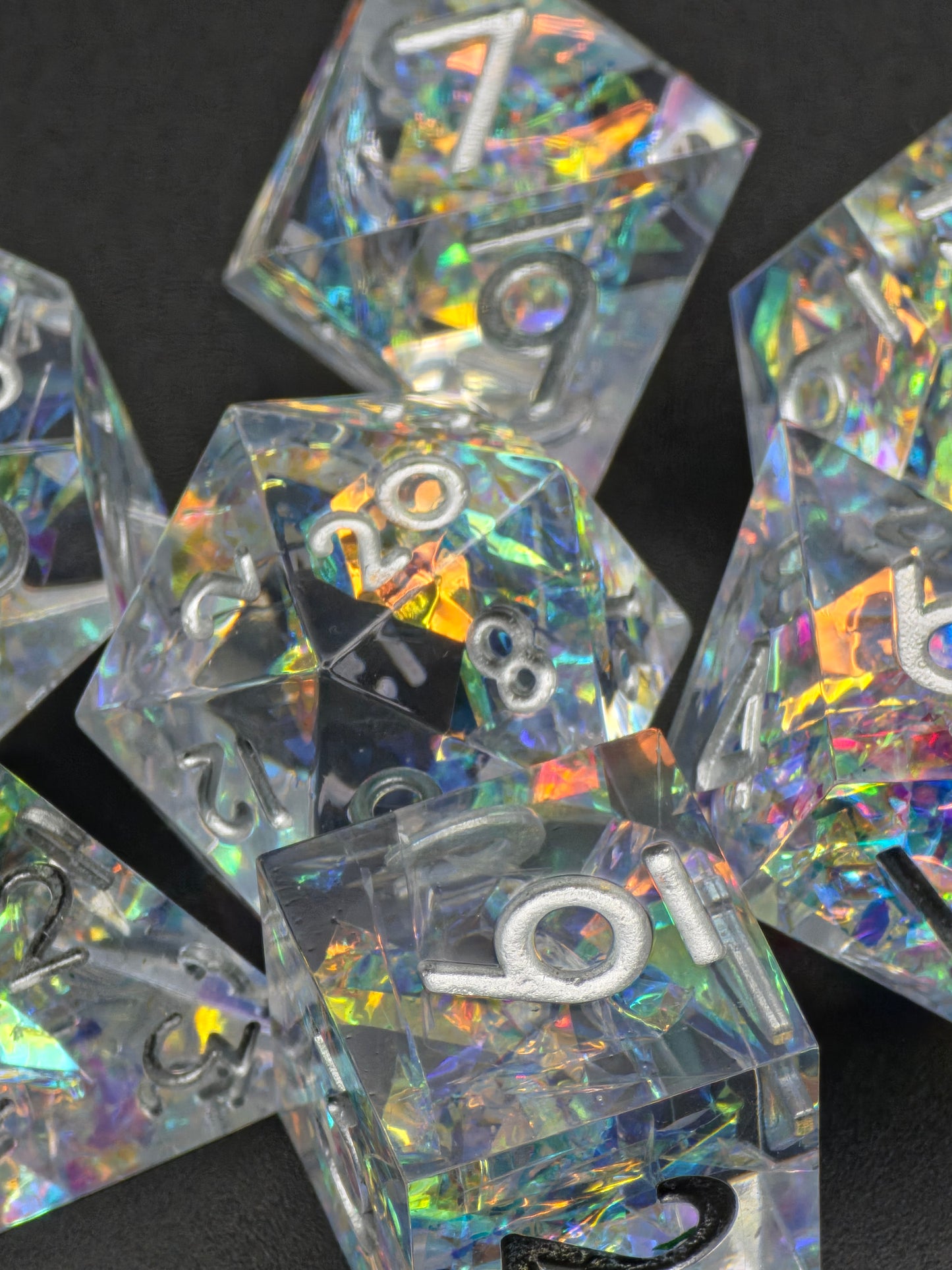 Aether Shards – holografisches DnD Würfelset aus klarem Resin mit regenbogenartigen Reflexionen im Sonnenlicht. 
Aether Shards– holographic DnD dice set made of clear resin with rainbow reflections in sunlight.