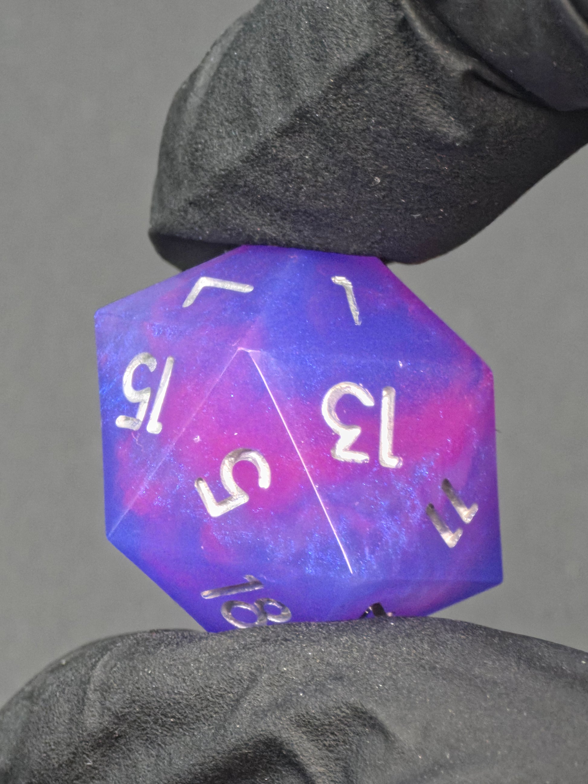 „Aetherfall D20“ aus hochwertigem Resin, lila-blauer Farbverlauf mit reflektierenden silbernen Zahlen. 
“Aetherfall D20” made of high-quality resin, purple-blue gradient with reflective silver numbers.