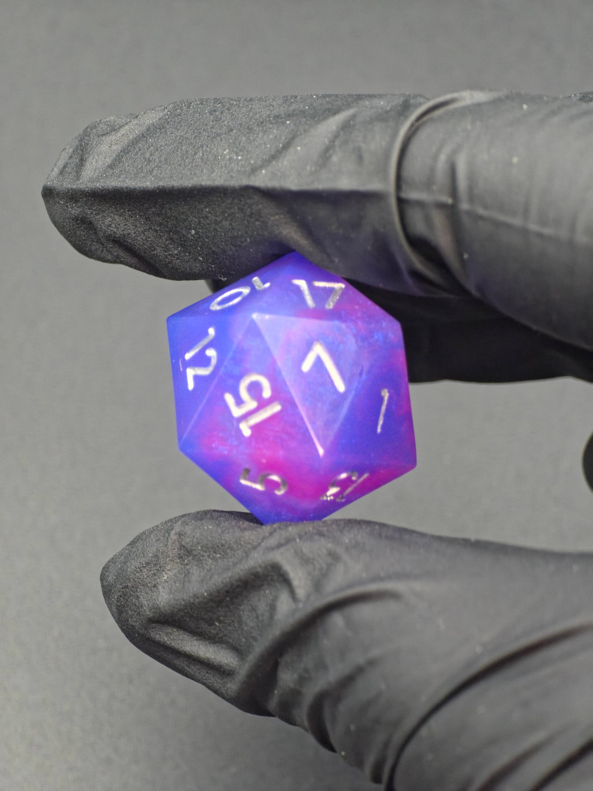 „Aetherfall D20“ im natürlichen Licht, lila-blauer Würfel mit sanftem Farbverlauf und silbernen Zahlen. 
“Aetherfall D20” in natural light, purple-blue die with soft gradient and silver numbering.
