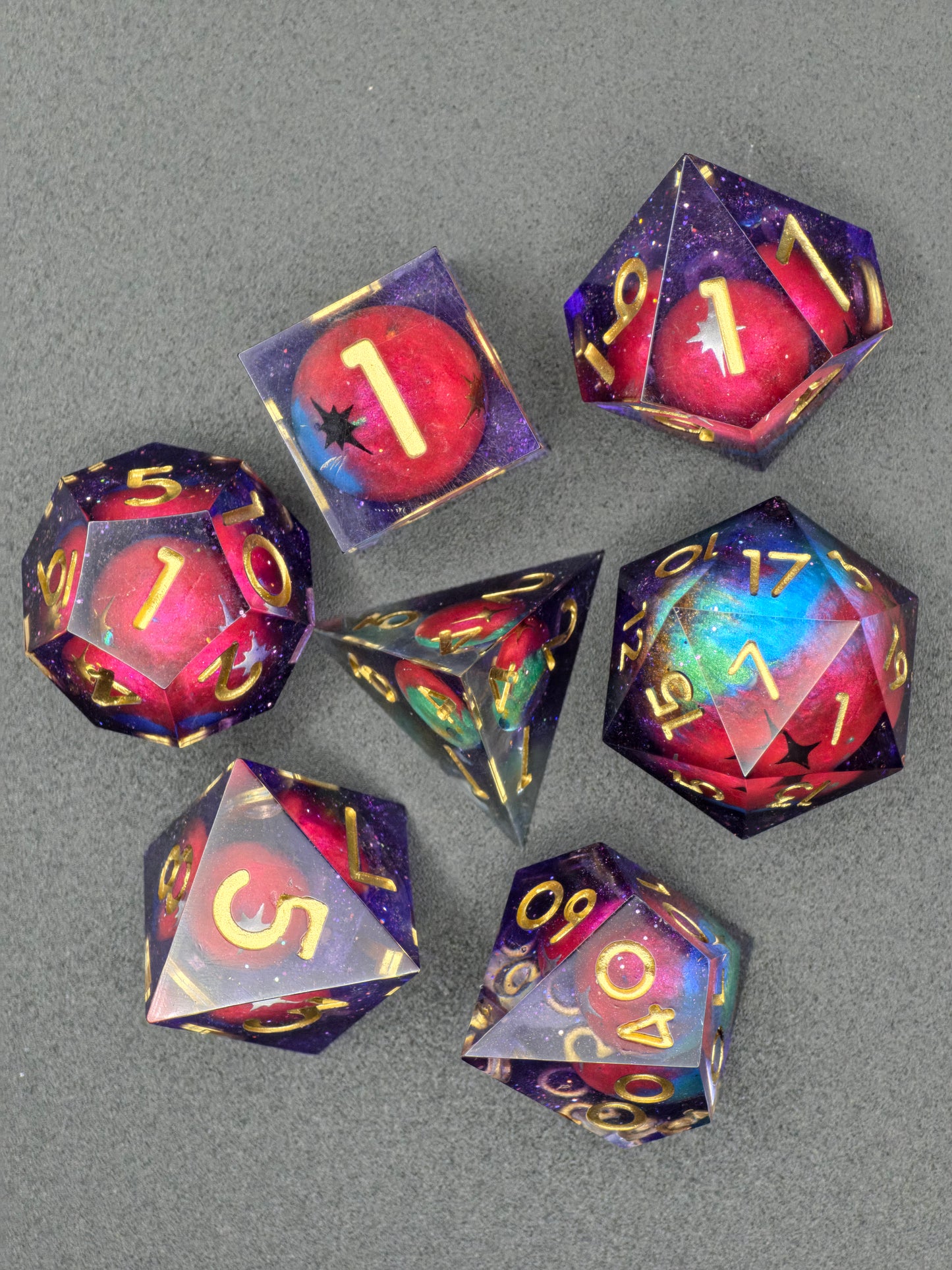 Handaufnahme des „Astral Realms“ Würfelsets mit schimmernden Galaxy-Farben und Planetenpartikeln.  
Hand shot of the “Astral Realms” dice set with shimmering galaxy colors and embedded planet particles.
