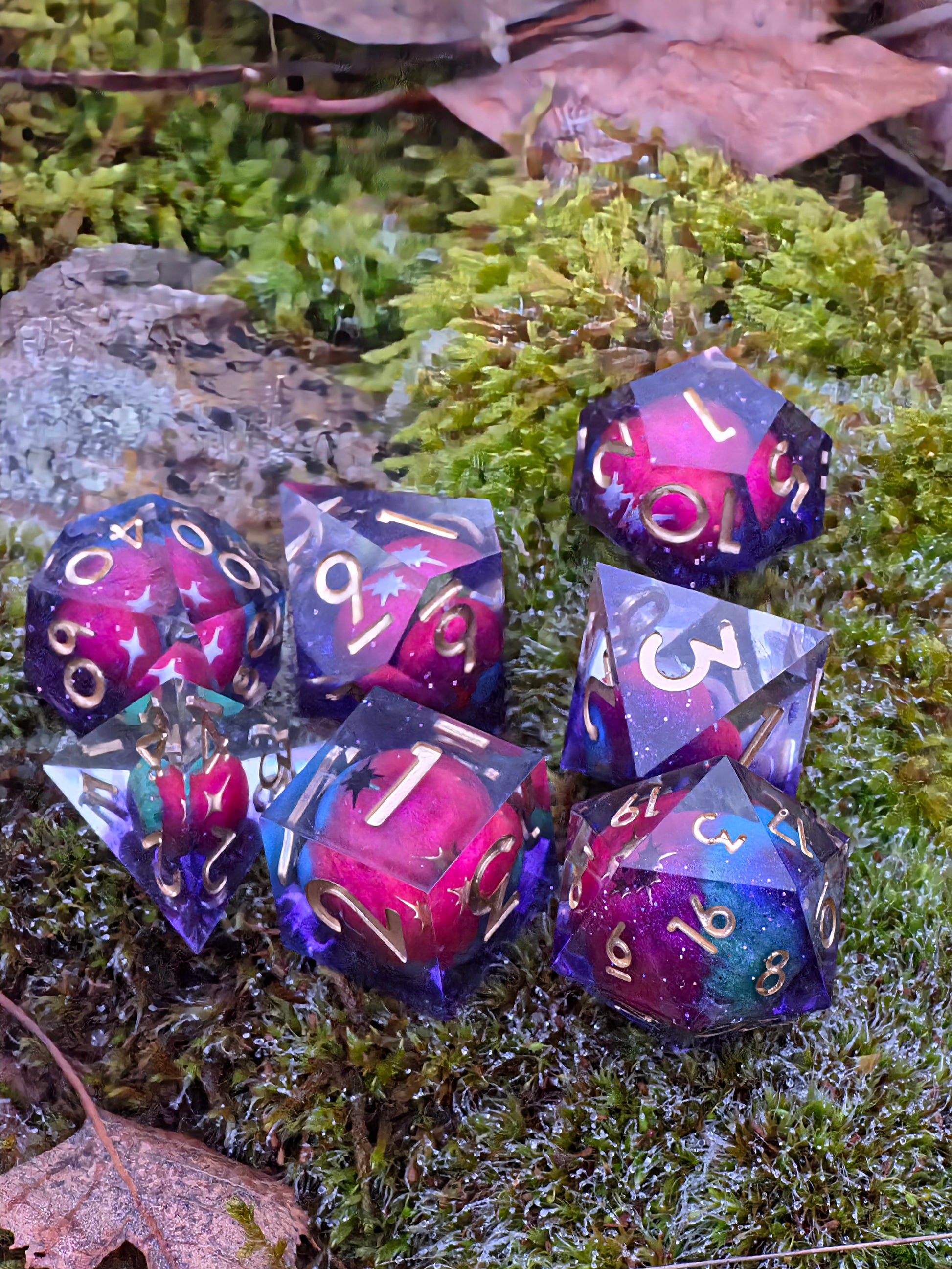 Komplettes „Astral Realms“ Würfelset auf neutralem Hintergrund – violett, blau, türkis, gold.  
Full “Astral Realms” dice set on a neutral background – violet, blue, turquoise, gold.