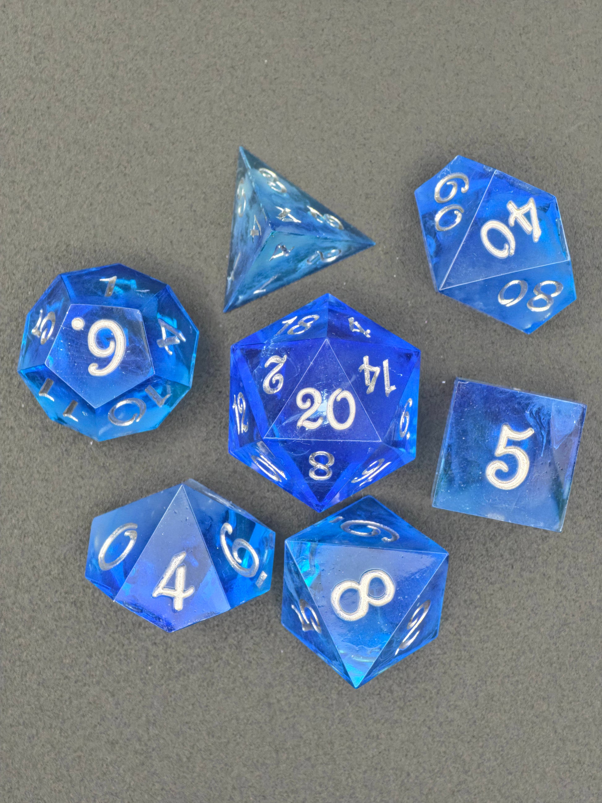 Detailansicht der Oberfläche und Zahlen des Astrallicht Blau Nebula Glow Würfelsets.  
Close-up of the surface and numbers of the Astrallicht Blau nebula glow dice set.
