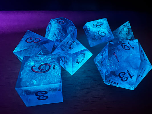 Astrallicht Blau handgemachtes Nebula Glow Würfelset in leuchtendem Blau mit sanftem Leuchteffekt, 7-teilig.  
Astrallicht Blau handmade nebula glow dice set in luminous blue with a soft glow effect, 7-piece set.
