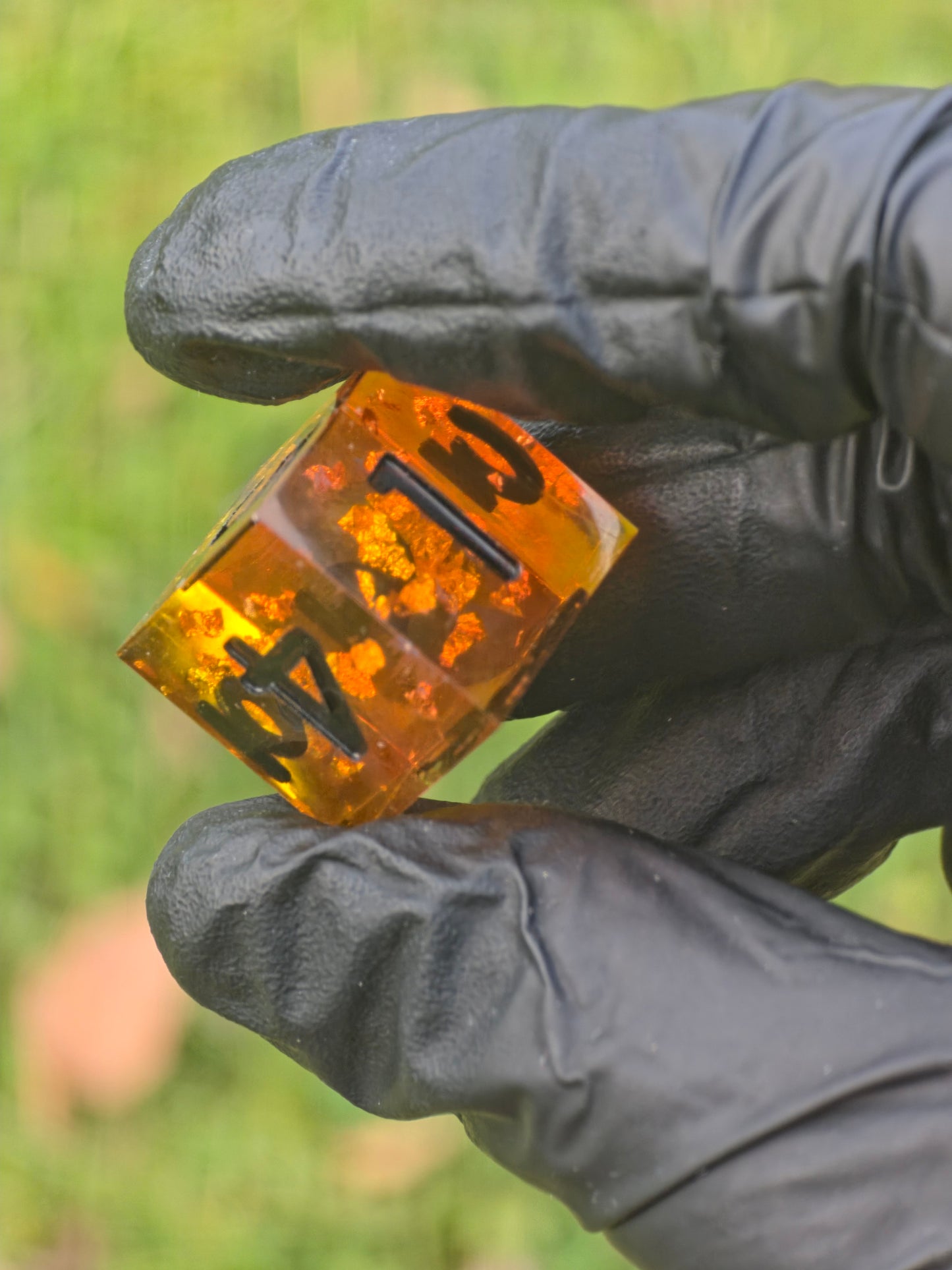 Amber-Orange D6 „Bernstein Fragment“ im Sonnenlicht – goldene Partikel und klare Resinstruktur.  
Amber Fragment D6 in sunlight – golden particles and clear resin structure.