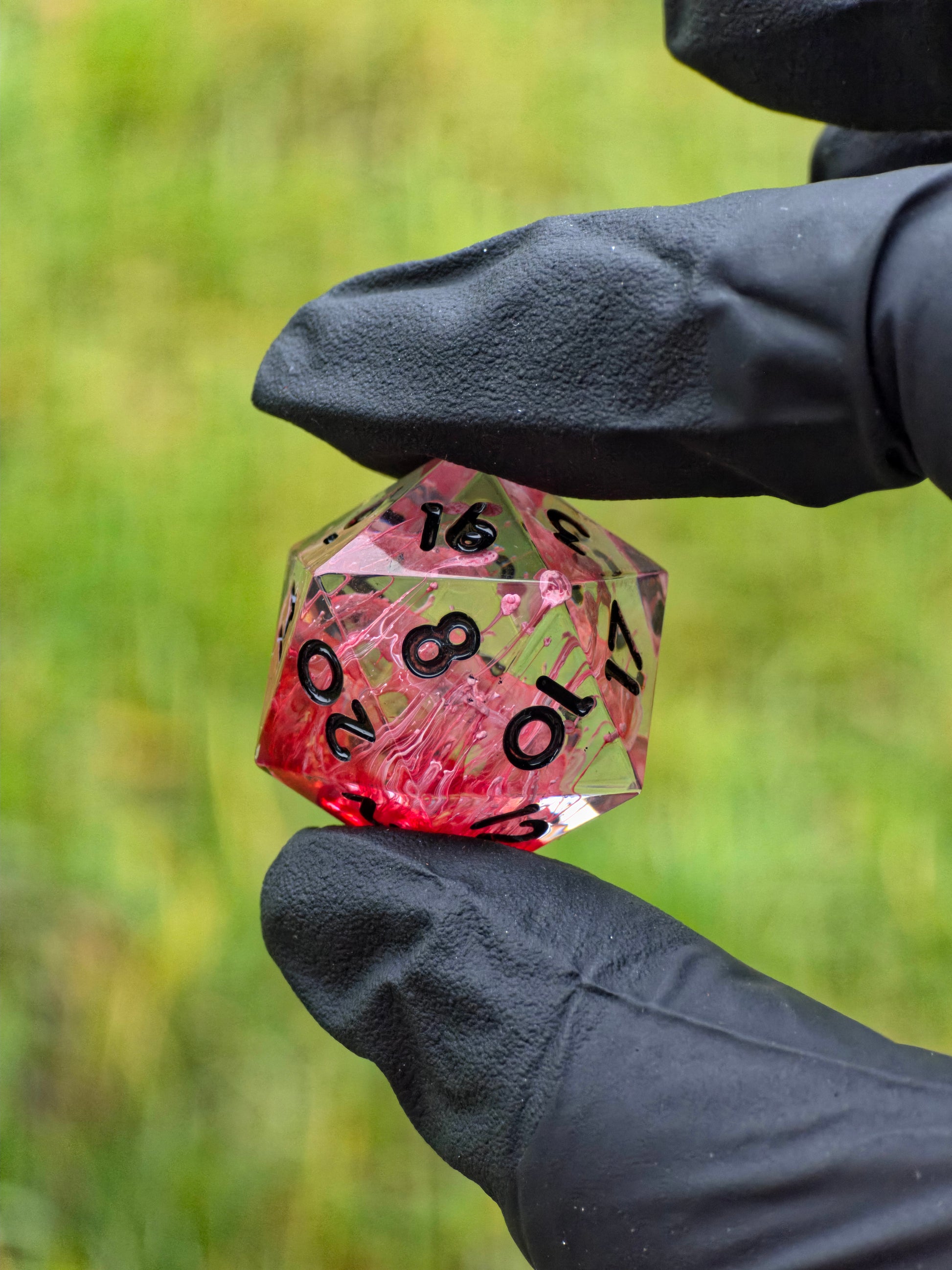 Crimson Veins D20 Würfel im natürlichen Licht mit intensiven roten Petri-Strukturen.  
Crimson Veins D20 dice in natural light showing intense red petri structures.