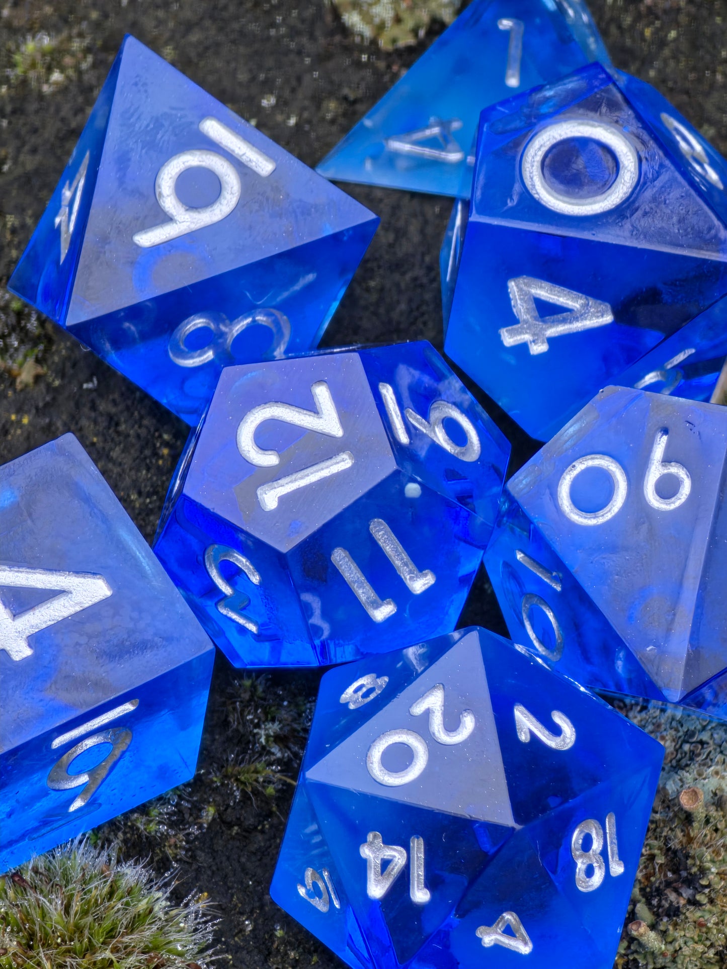 Detailansicht der Oberfläche und Zahlen des Midnight Nebula Glow Würfelsets.  
Close-up of the surface and numbers of the Midnight Nebula glow dice set.