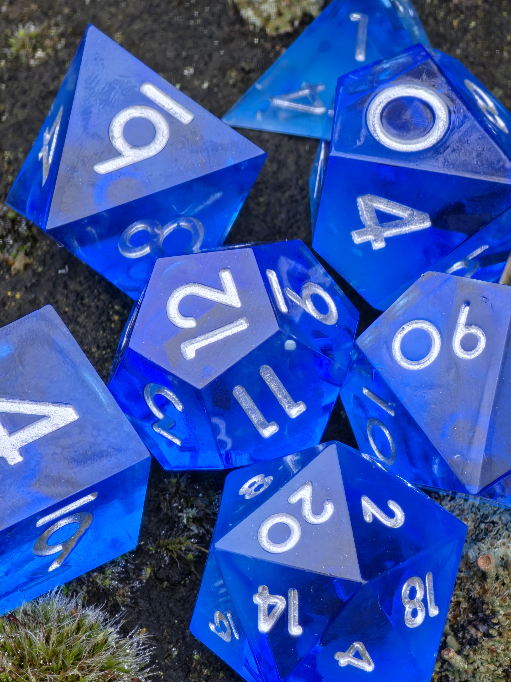 Detailansicht der Oberfläche und Zahlen des Midnight Nebula Glow Würfelsets.  
Close-up of the surface and numbers of the Midnight Nebula glow dice set.