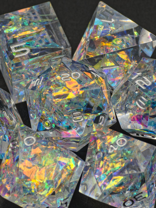 Prismatic Aether – klares holografisches DnD Würfelset mit irisierenden Regenbogeneffekten im Sonnenlicht. 
Prismatic Aether – clear holographic DnD dice set with iridescent rainbow effects in outdoor light.