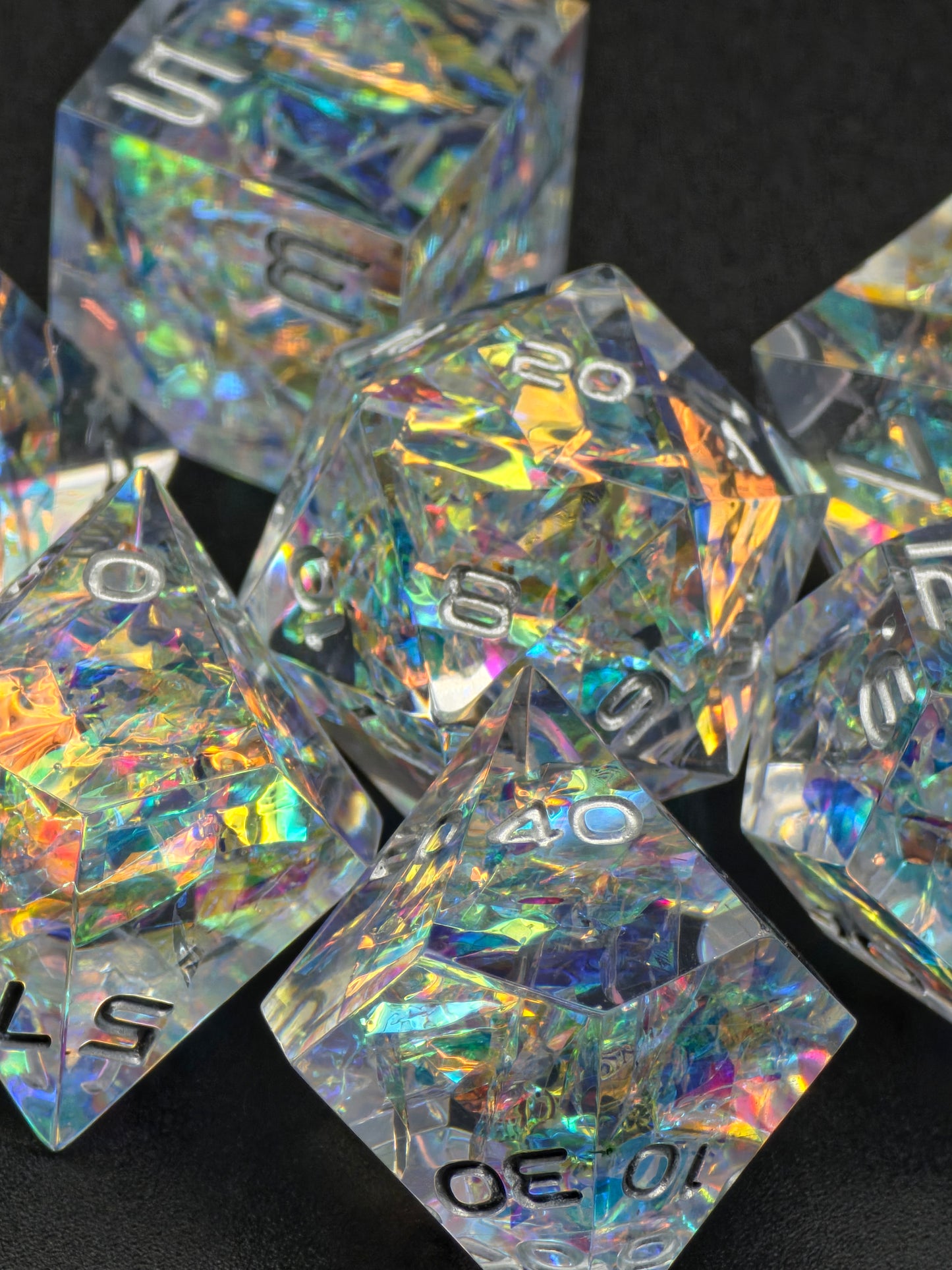 Prismatic Aether Würfelset im Freien – glänzende, transparente Polyeder mit irisierendem Effekt. 
Prismatic Aether dice set outdoors – glossy transparent polyhedrals with iridescent effect.