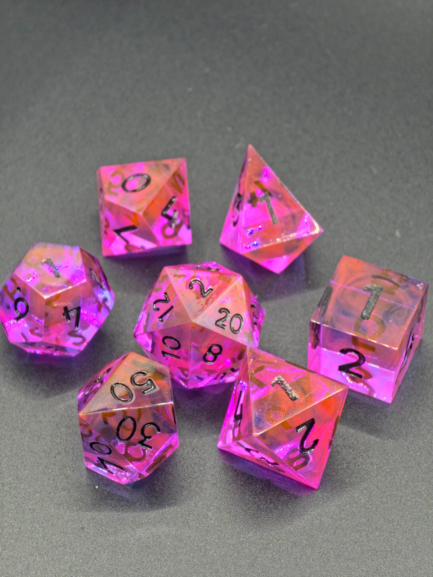 Galerieansicht des Radiant Ember Polyedrischen Würfelsets aus verschiedenen Blickwinkeln.  
Gallery view of the Radiant Ember polyhedral dice set from multiple angles.
