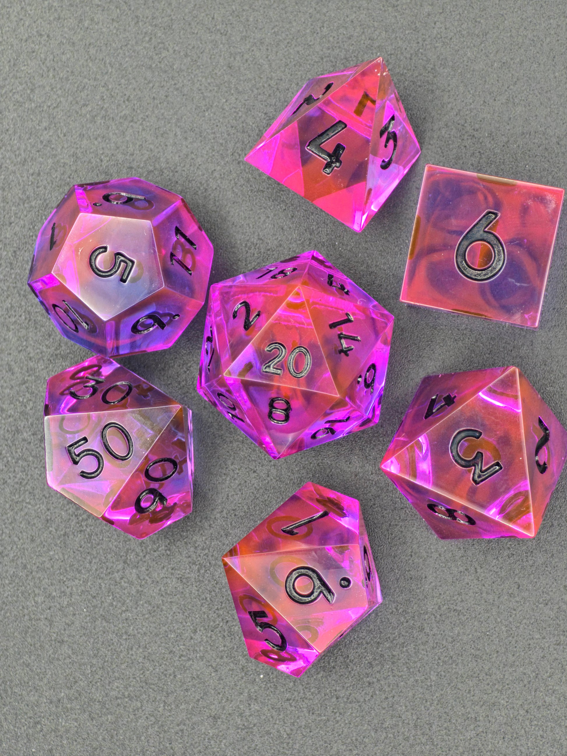 Detailansicht der schwarzen Zahlen und des leuchtenden Resin-Effekts im Radiant Ember Würfelset.  
Close-up view of black numbers and glowing resin effect in the Radiant Ember dice set.