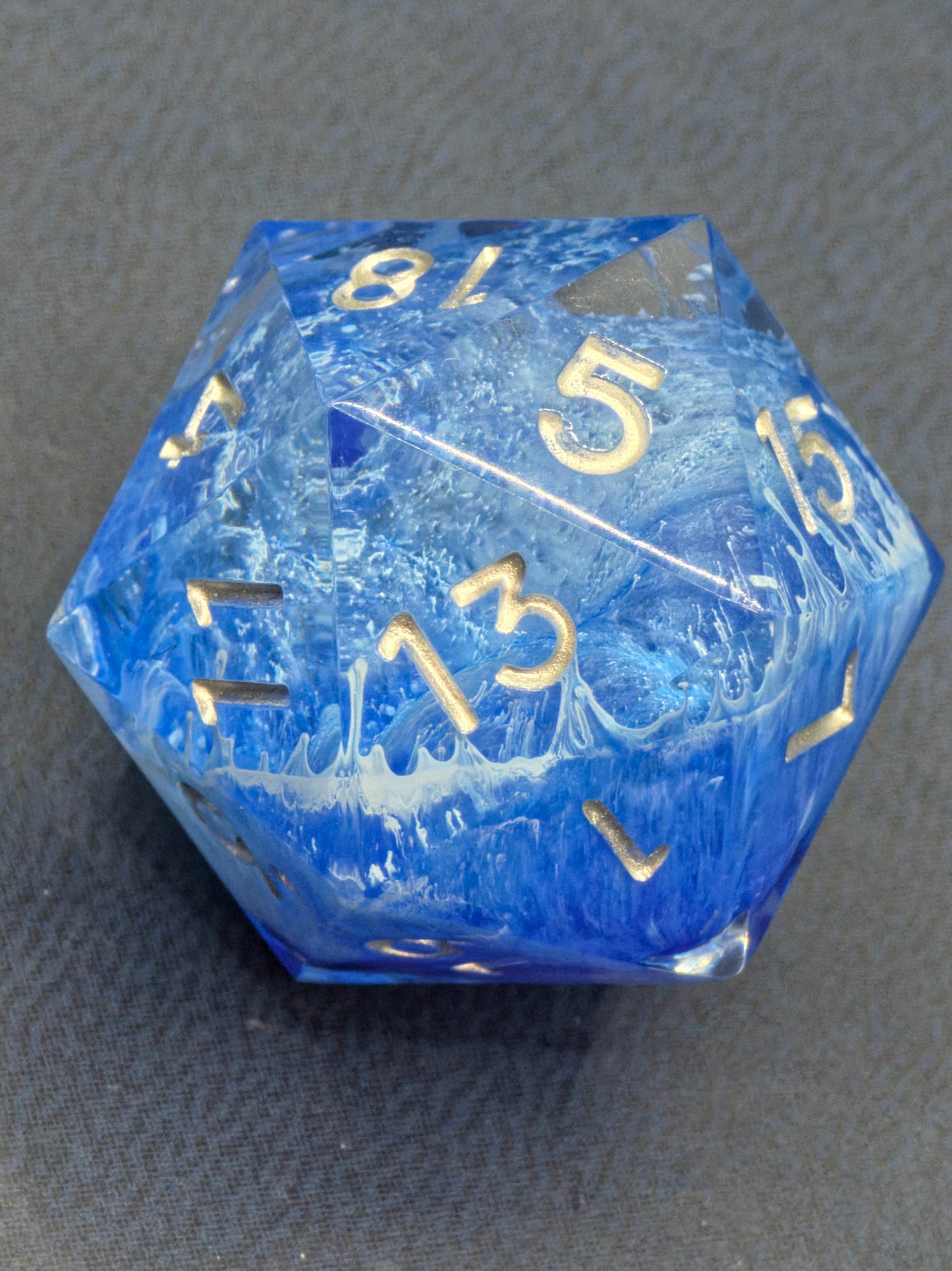 Schrägansicht des „Stormsealed Core“ – goldene Zahlen auf blau-weißem Blizzard-Hintergrund.  
Angled view of the “Stormsealed Core” – gold numbers on a blue-white blizzard background.