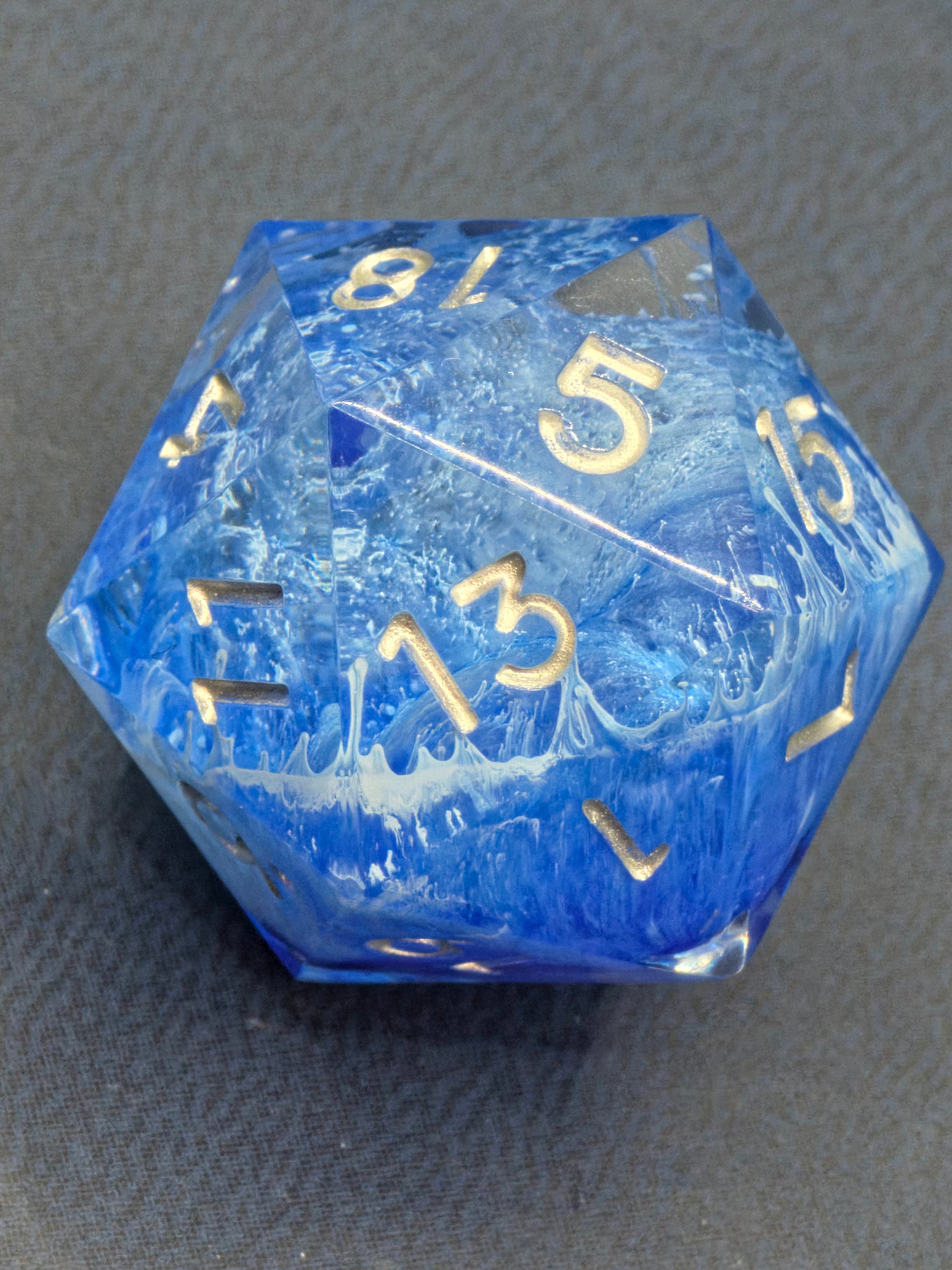 Schrägansicht des „Stormsealed Core“ – goldene Zahlen auf blau-weißem Blizzard-Hintergrund.  
Angled view of the “Stormsealed Core” – gold numbers on a blue-white blizzard background.