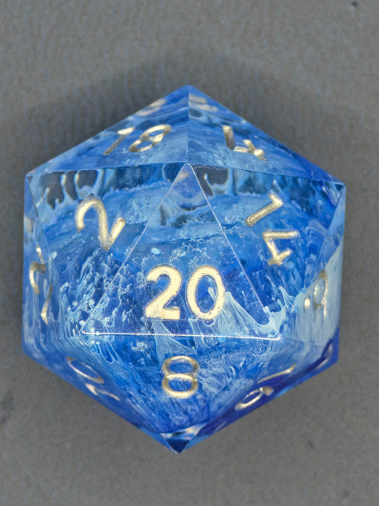 „Stormsealed Core“ einzelner D20 – eisblauer Resinwürfel mit weißen Blizzard-Adern und goldenen Zahlen.  
“Stormsealed Core” single D20 – ice-blue resin die with white blizzard veins and gold numbers.
