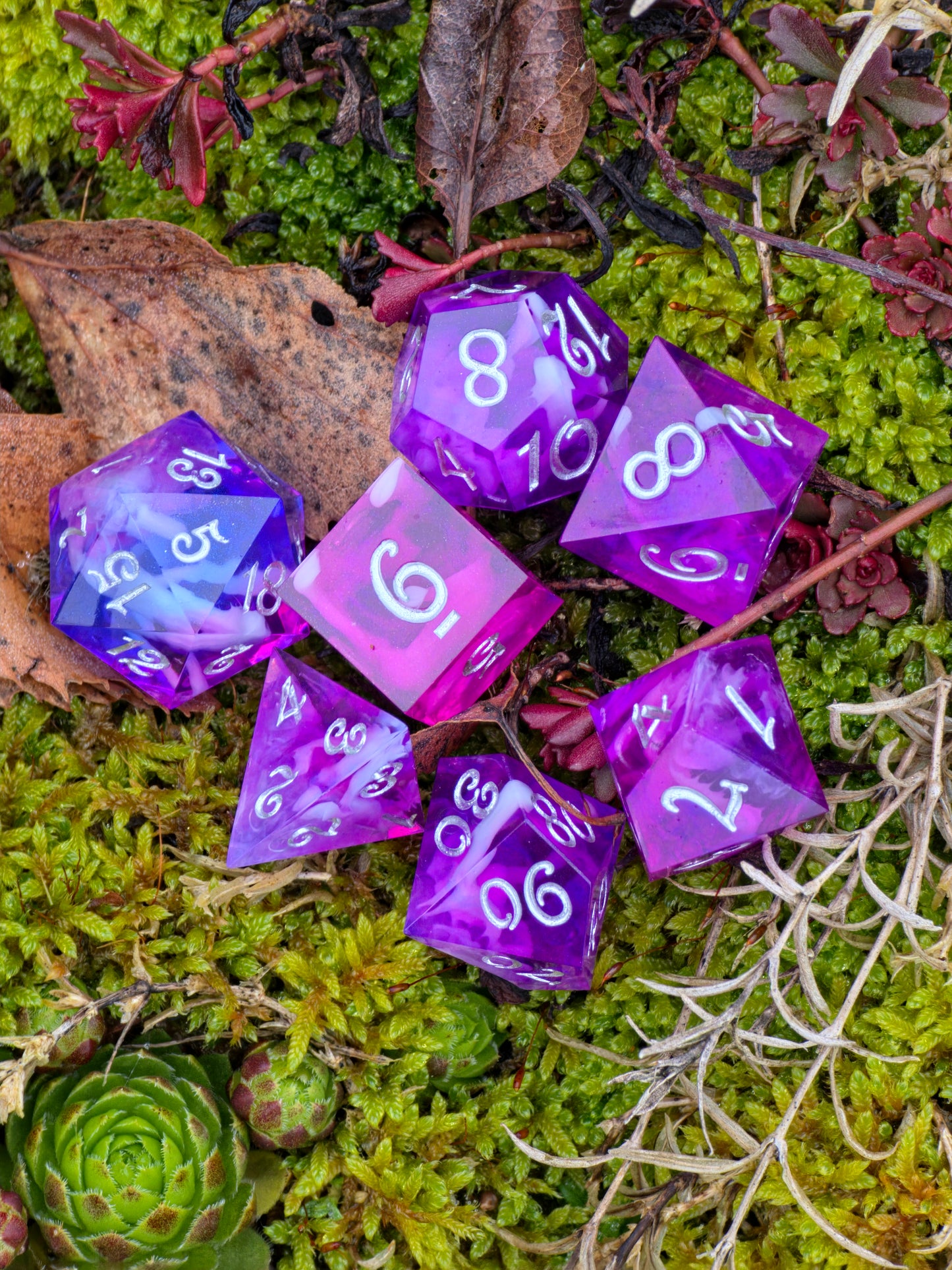 Galerieansicht des Violet Veil Polyedrischen Würfelsets aus mehreren Blickwinkeln.  
Gallery view of the Violet Veil polyhedral dice set from multiple angles.