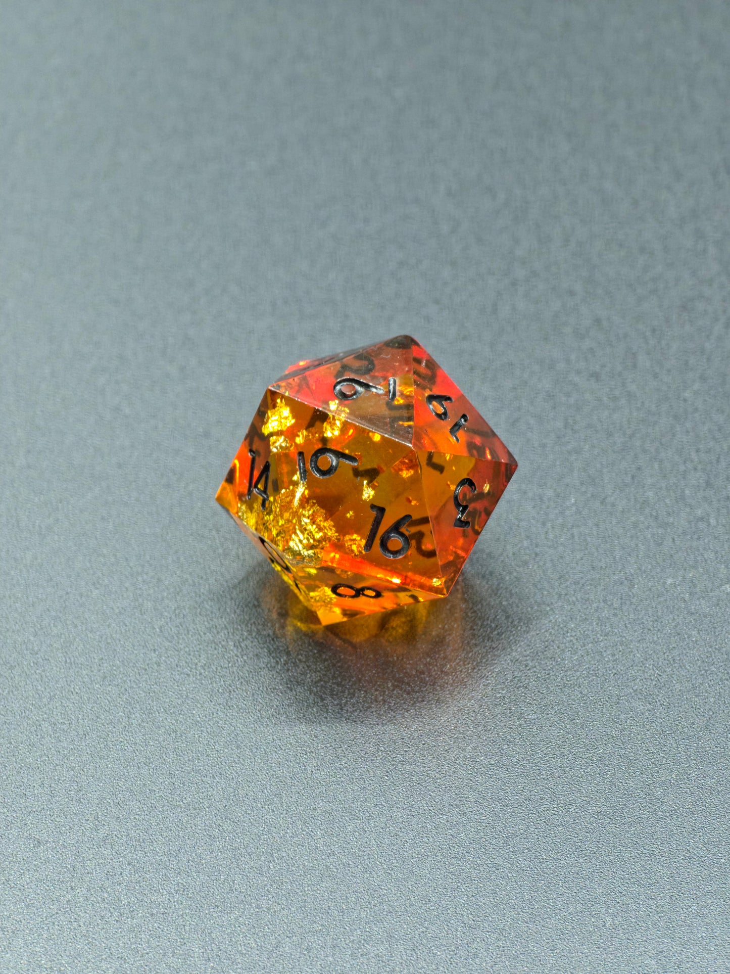 Detailaufnahme des „Amber Bernstein“ – schimmernde Blattgoldstücke im warmen Harz.  
Close-up of “Amber Bernstein” – shimmering gold leaf pieces inside warm amber resin.