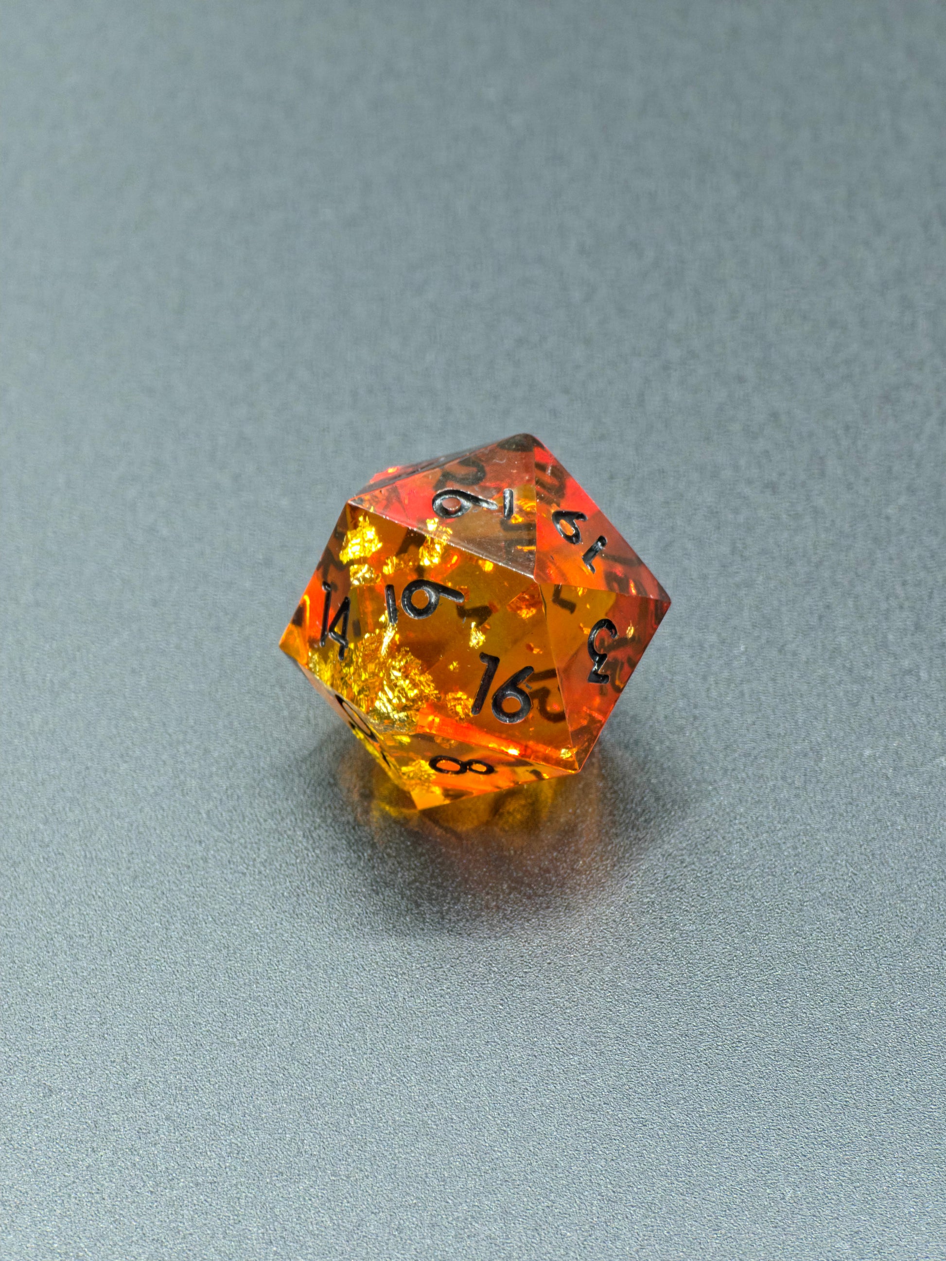 Detailaufnahme des „Amber Bernstein“ – schimmernde Blattgoldstücke im warmen Harz.  
Close-up of “Amber Bernstein” – shimmering gold leaf pieces inside warm amber resin.