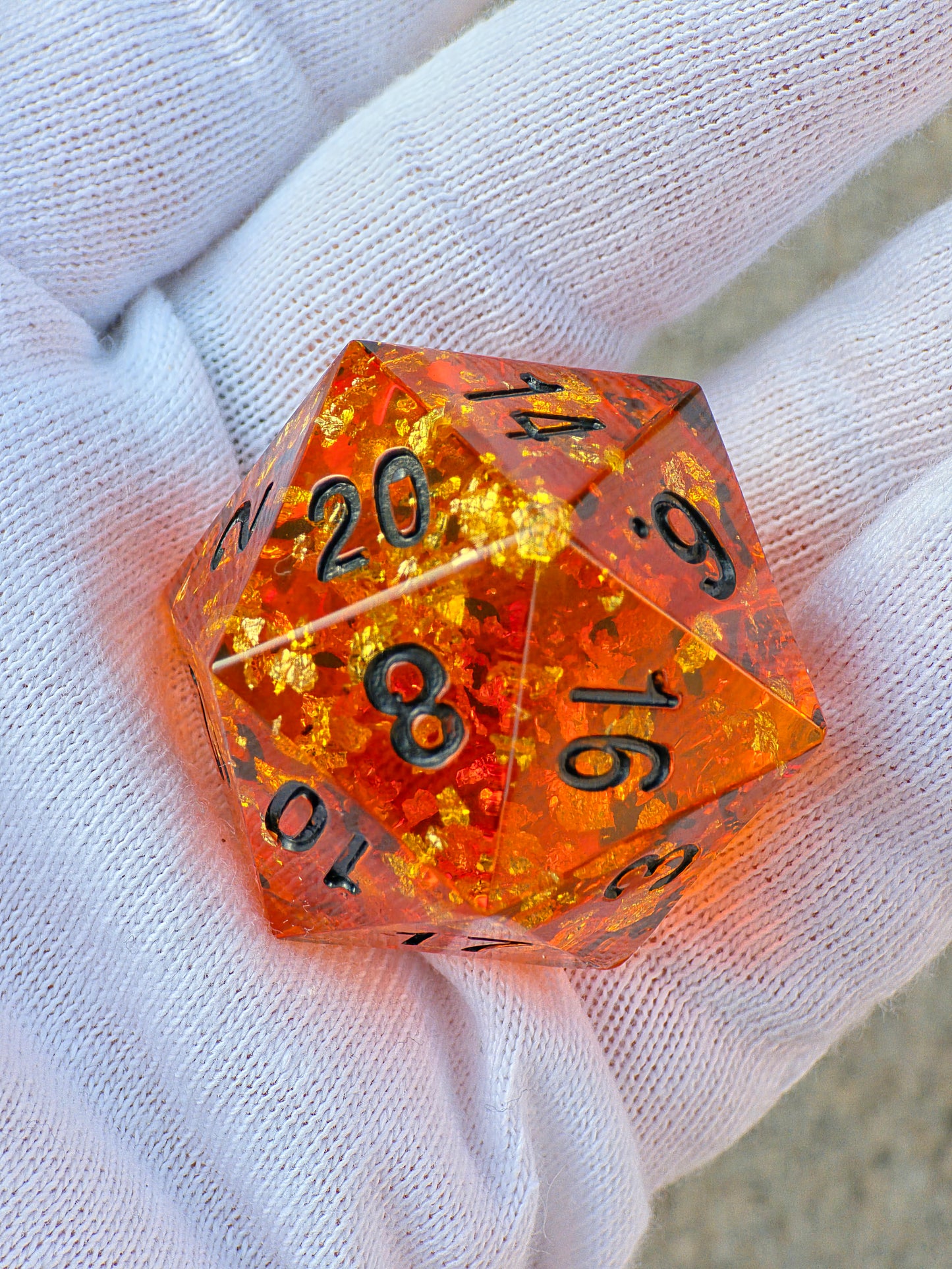 Handgemachter großer D20 „Amber Chonk“ – 35 mm Resinwürfel im Bernstein-Stil mit goldenen Einschlüssen.  
Handmade large D20 “Amber Chonk” – 35 mm resin die in amber style with golden inclusions.