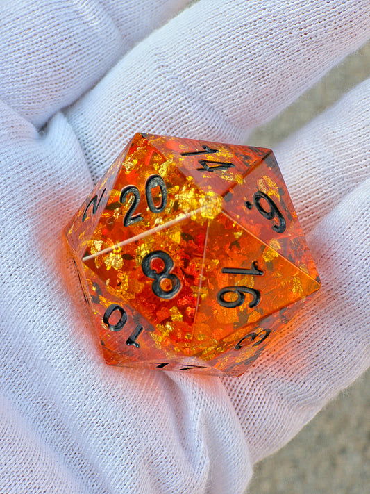 Handgemachter großer D20 „Amber Chonk“ – 35 mm Resinwürfel im Bernstein-Stil mit goldenen Einschlüssen.  
Handmade large D20 “Amber Chonk” – 35 mm resin die in amber style with golden inclusions.