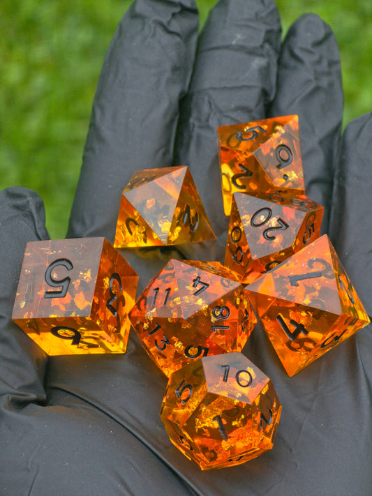 Handgemachtes DnD-Würfelset „Amber Essence“ – transparentes Harz in Gold und Orange.  
Handmade DnD dice set “Amber Essence” – transparent resin in gold and orange tones.