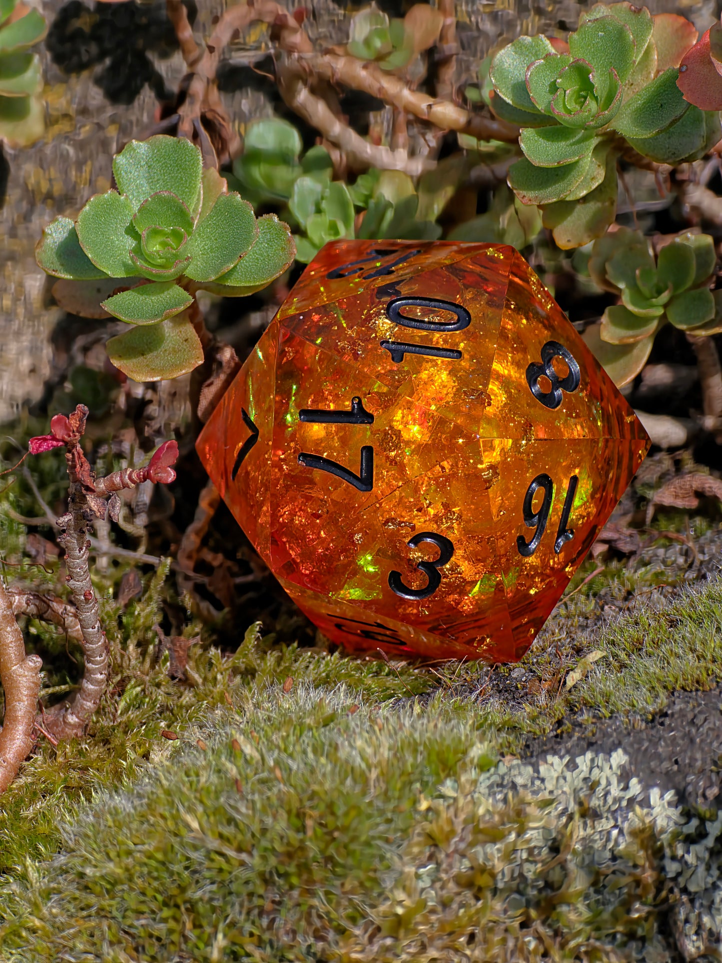 Handgemachter D20 „Amber Essence“ – großer Liquid Core Würfel im Bernstein-Look mit goldenen Schimmerpartikeln.  
Handmade D20 “Amber Essence” – large liquid core die in amber look with golden shimmer particles.