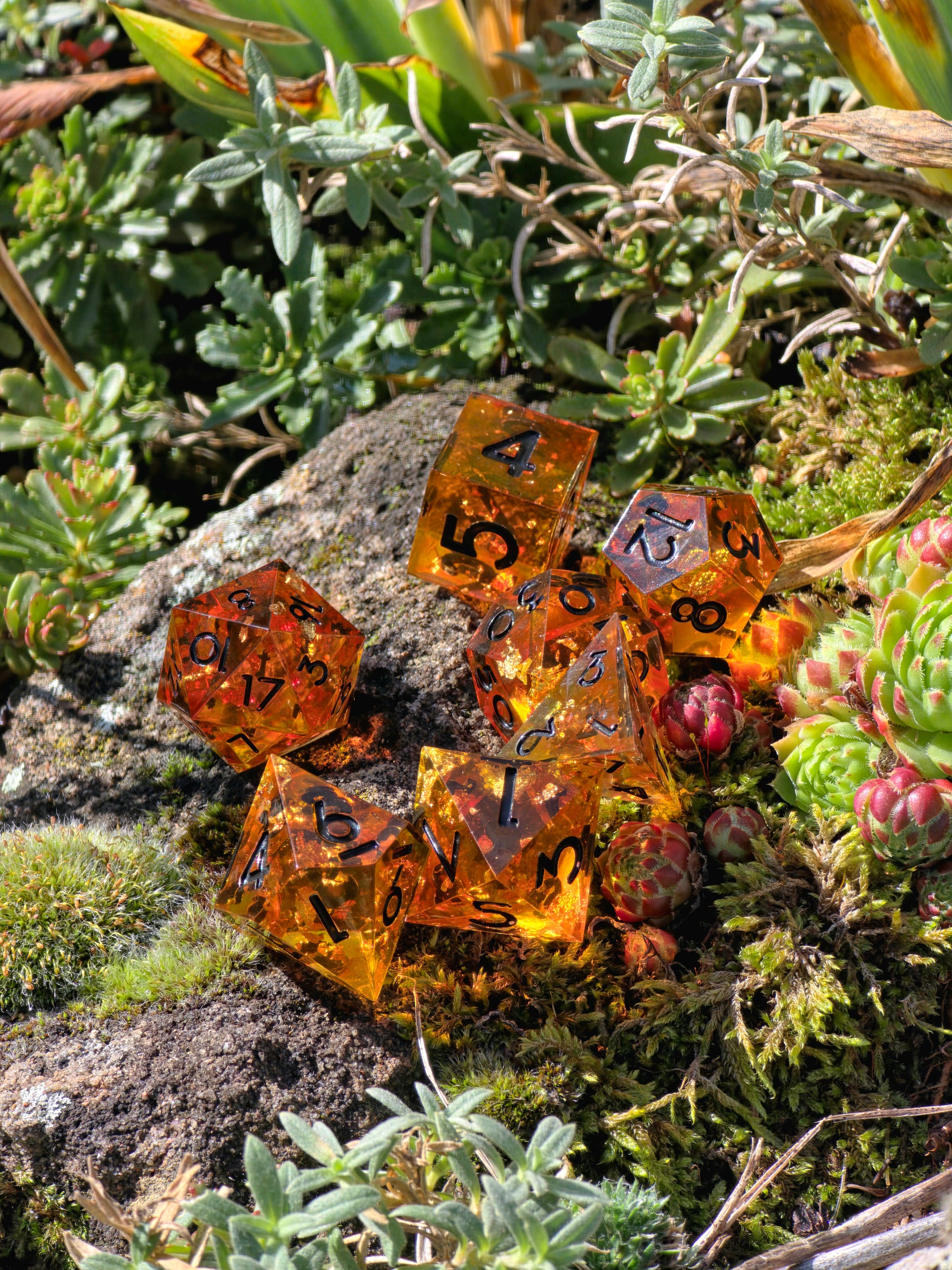 „Amber Glow“ in der Hand – goldene Zahlen auf leuchtend orangefarbenem Harz.  
“Amber Glow” held in hand – golden numbers on glowing orange resin.