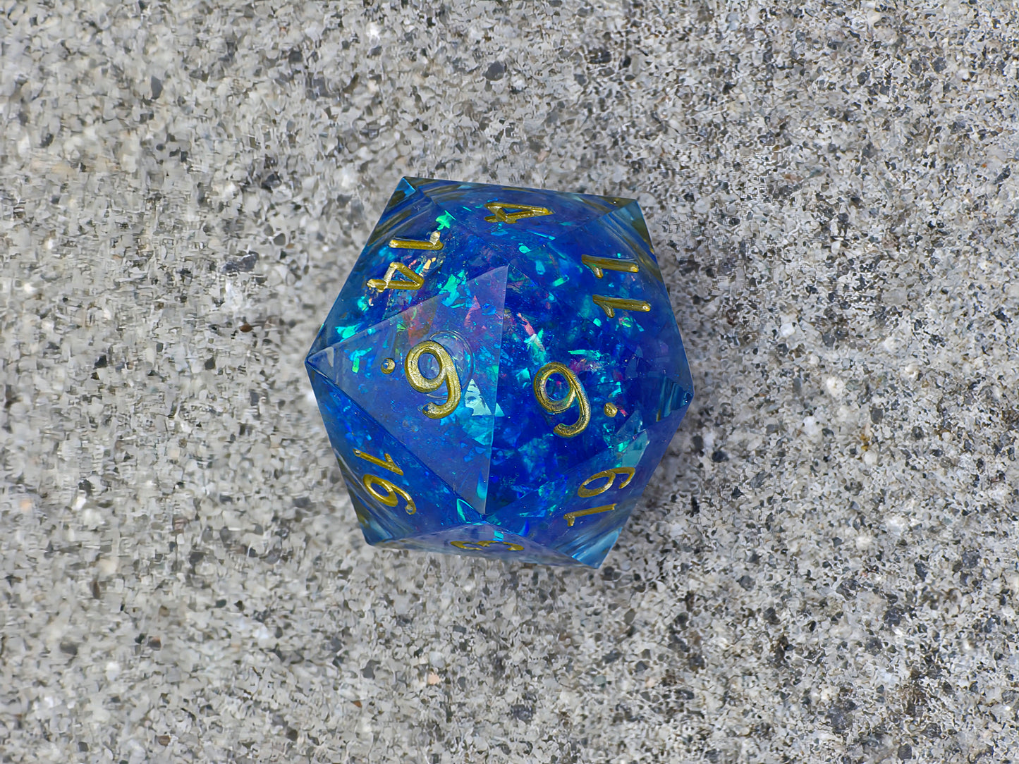 Handgemachter D20 „Arcane Energy“ – großer Liquid Core Würfel in tiefem Blau mit goldenem Schimmer.  
Handmade D20 “Arcane Energy” – large liquid core die in deep blue with golden shimmer.