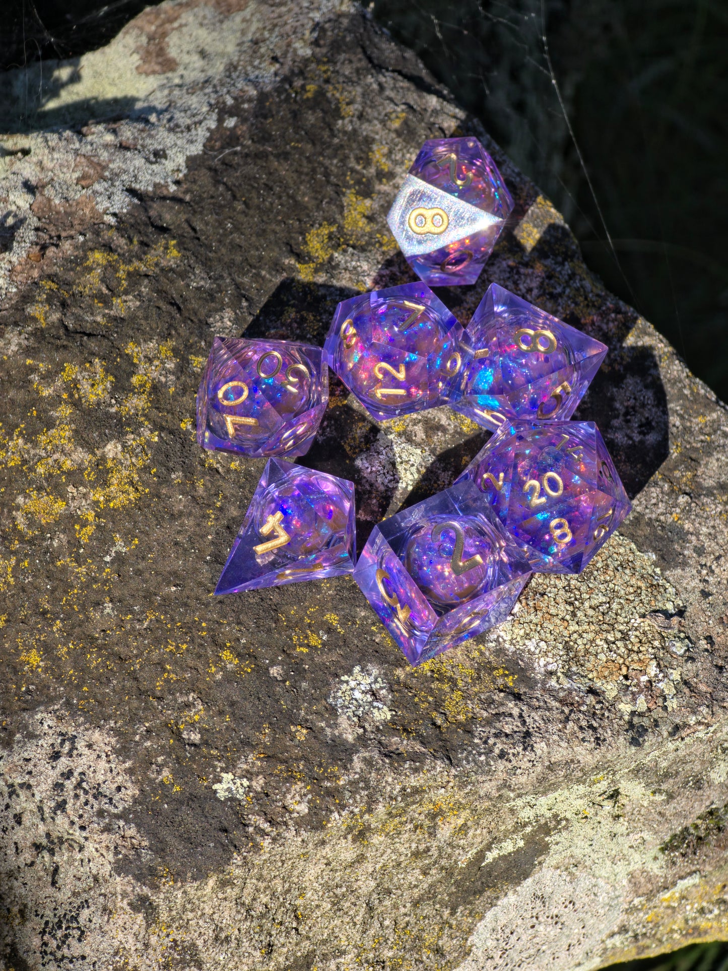 Detailaufnahme des „Aurora Amethyst Liquid Core“ – flüssiger Kern mit schimmernden Partikeln.  
Close-up of “Aurora Amethyst Liquid Core” – liquid core with shimmering particles inside.