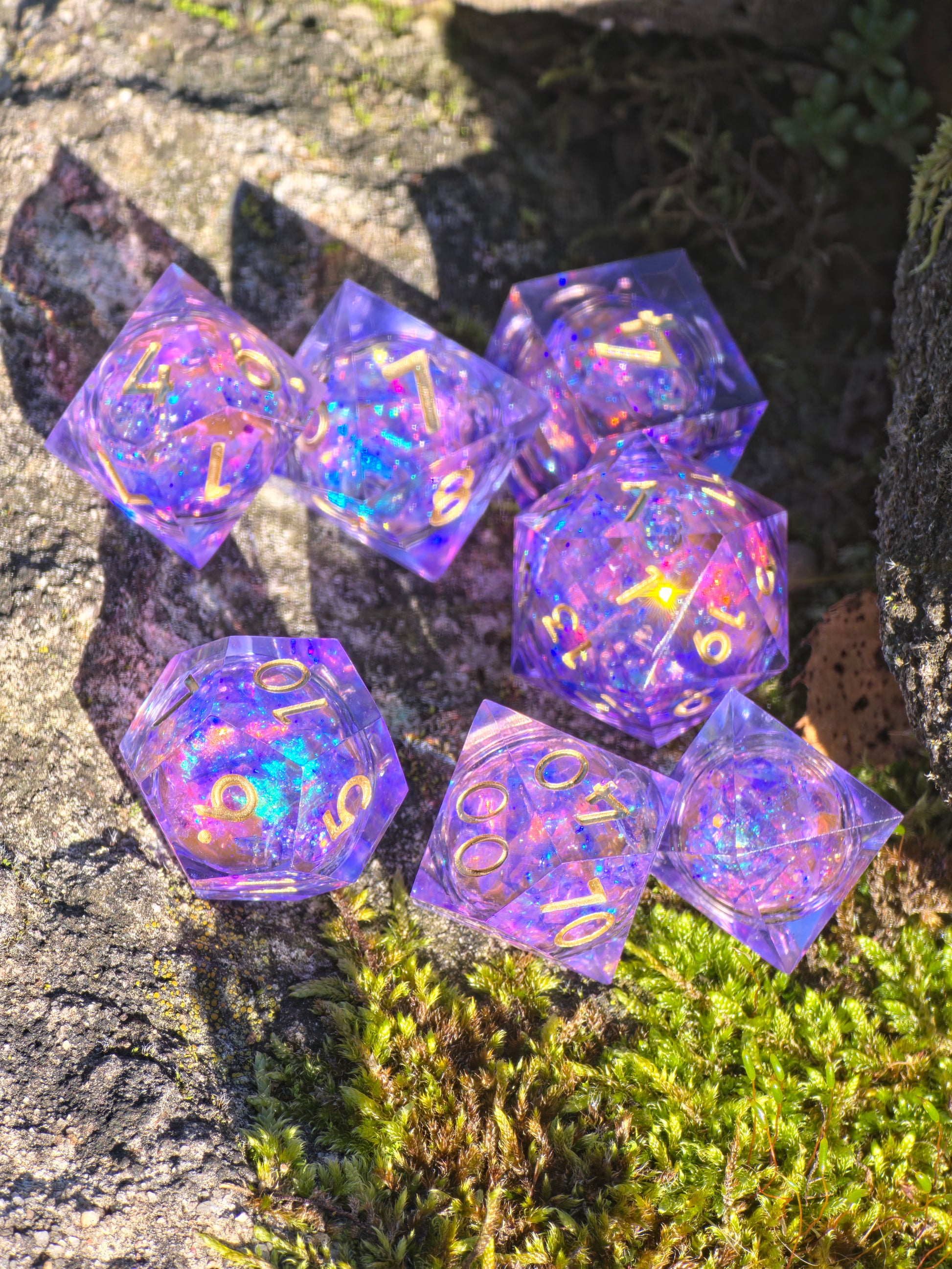 Handgemachtes DnD-Würfelset „Aurora Amethyst Liquid Core“ – violett-blaue Würfel mit goldenem Schimmer.  
Handmade DnD dice set “Aurora Amethyst Liquid Core” – violet-blue resin dice with golden glow.