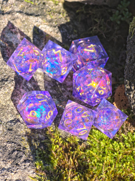 Handgemachtes DnD-Würfelset „Aurora Amethyst Liquid Core“ – violett-blaue Würfel mit goldenem Schimmer.  
Handmade DnD dice set “Aurora Amethyst Liquid Core” – violet-blue resin dice with golden glow.