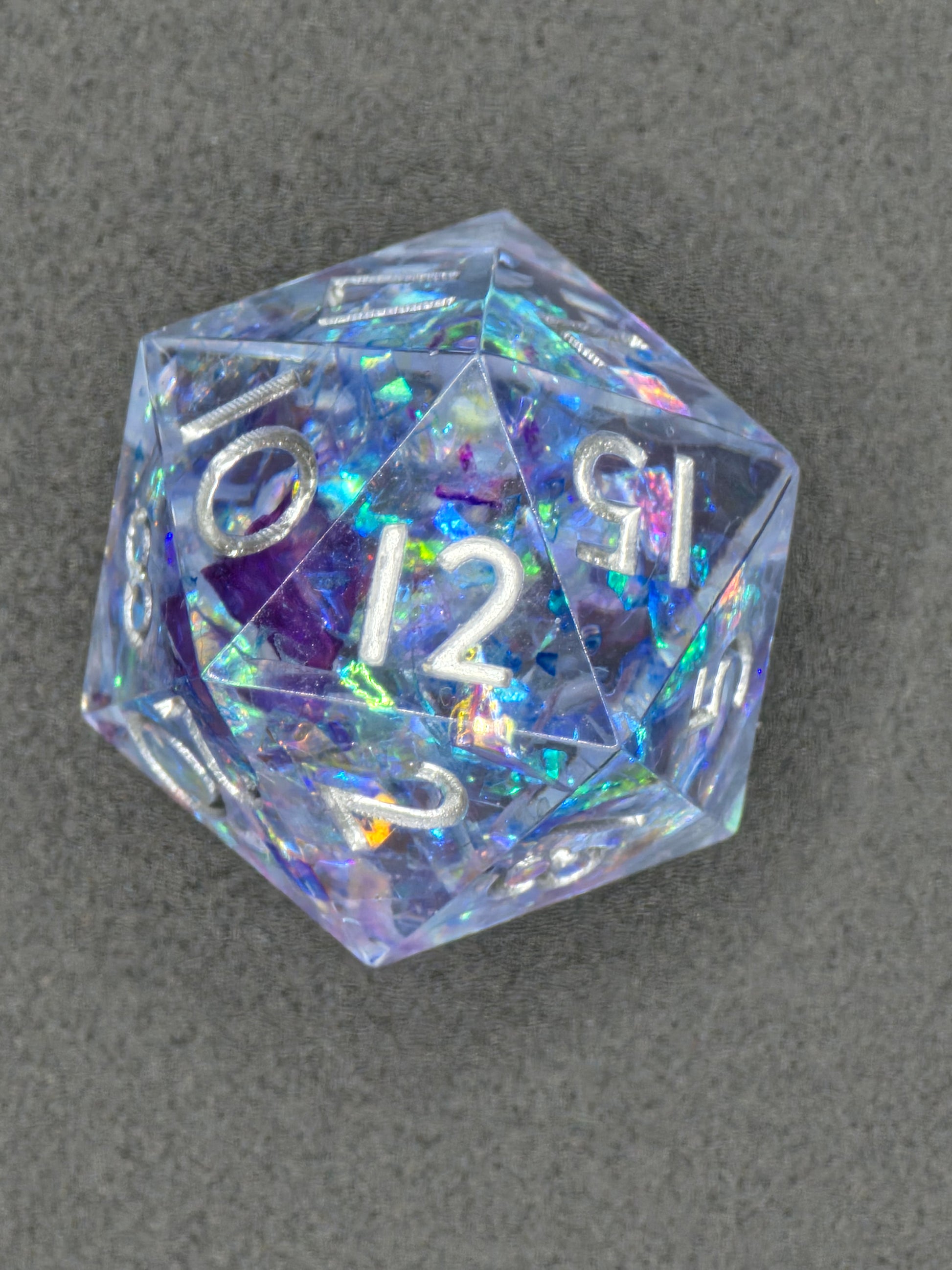Detailaufnahme des „Aurora Crystal“ D20 – zeigt schillernde Reflexe und gläserne Tiefe des Harzes.  
Close-up of the “Aurora Crystal” D20 – showing shimmering reflections and glass-like resin depth.