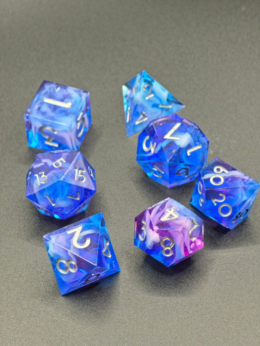 Handgemachtes DnD-Würfelset „Aurora Nebula – Mystic Sky“ – Würfel in Blau, Lila und Rosa mit Cloud-Effekt.  
Handmade DnD dice set “Aurora Nebula – Mystic Sky” – dice in blue, purple and pink tones with cloud effect.