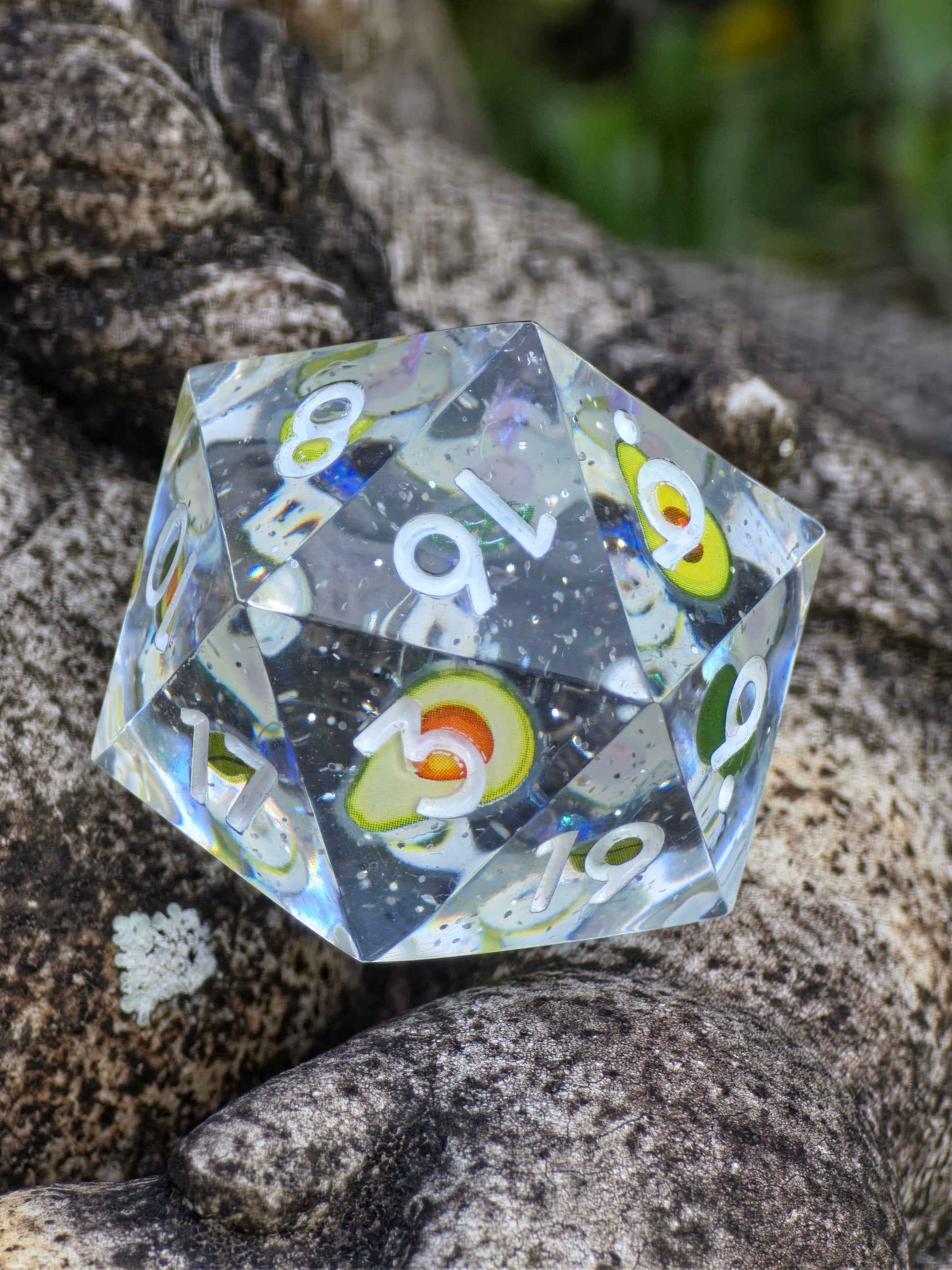 Detailaufnahme des „Avocado D20“ – zeigt Mini-Avocado-Motive im transparenten Harz mit feinen Lichtreflexen.  
Close-up of the “Avocado D20” – showing mini avocado motifs inside clear resin with delicate light reflections.