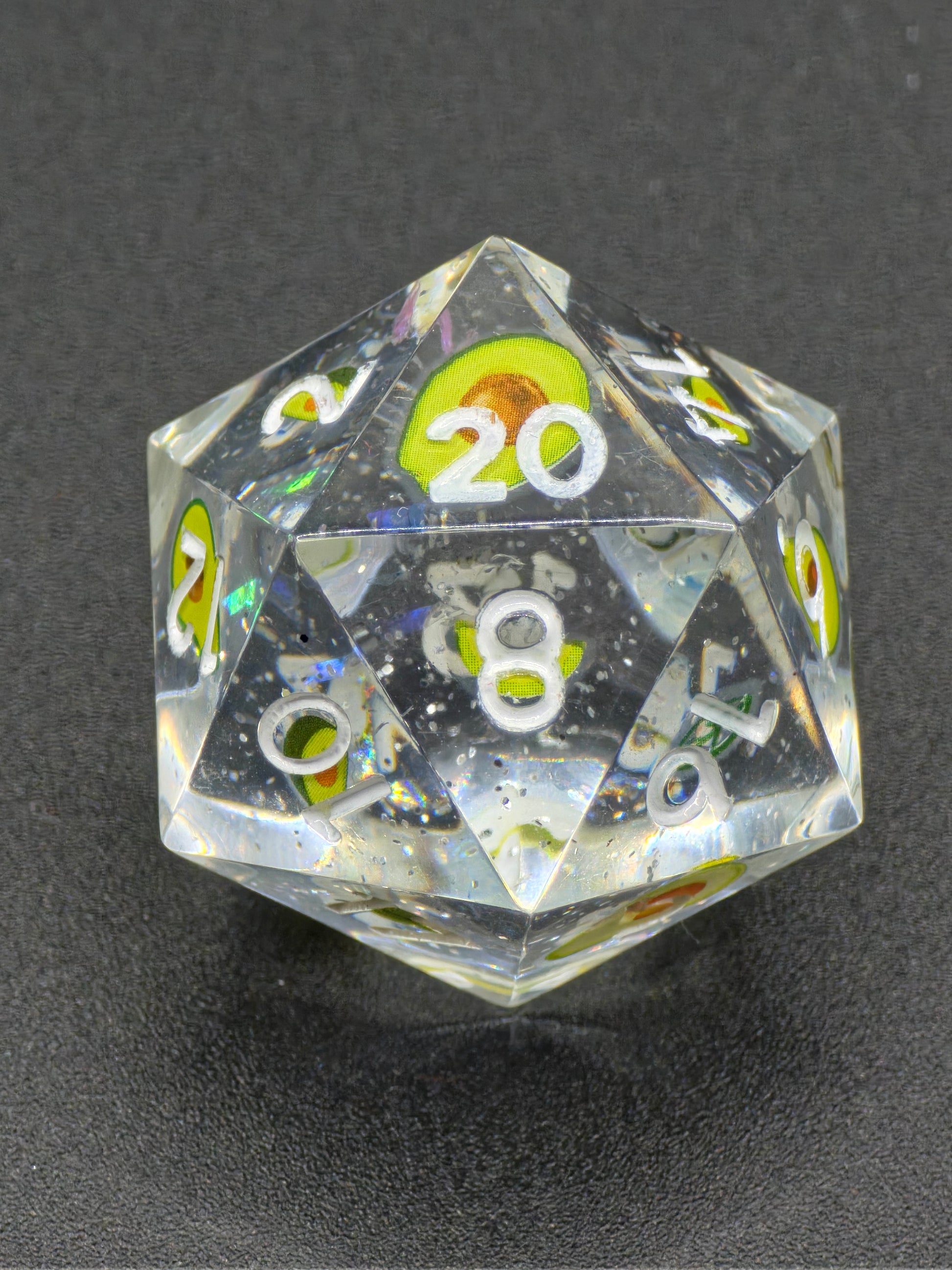 „Avocado D20“ in der Hand – spielerisches Design mit sichtbaren Miniaturen und glänzendem Finish.  
“Avocado D20” held in hand – playful design with visible miniatures and glossy finish.