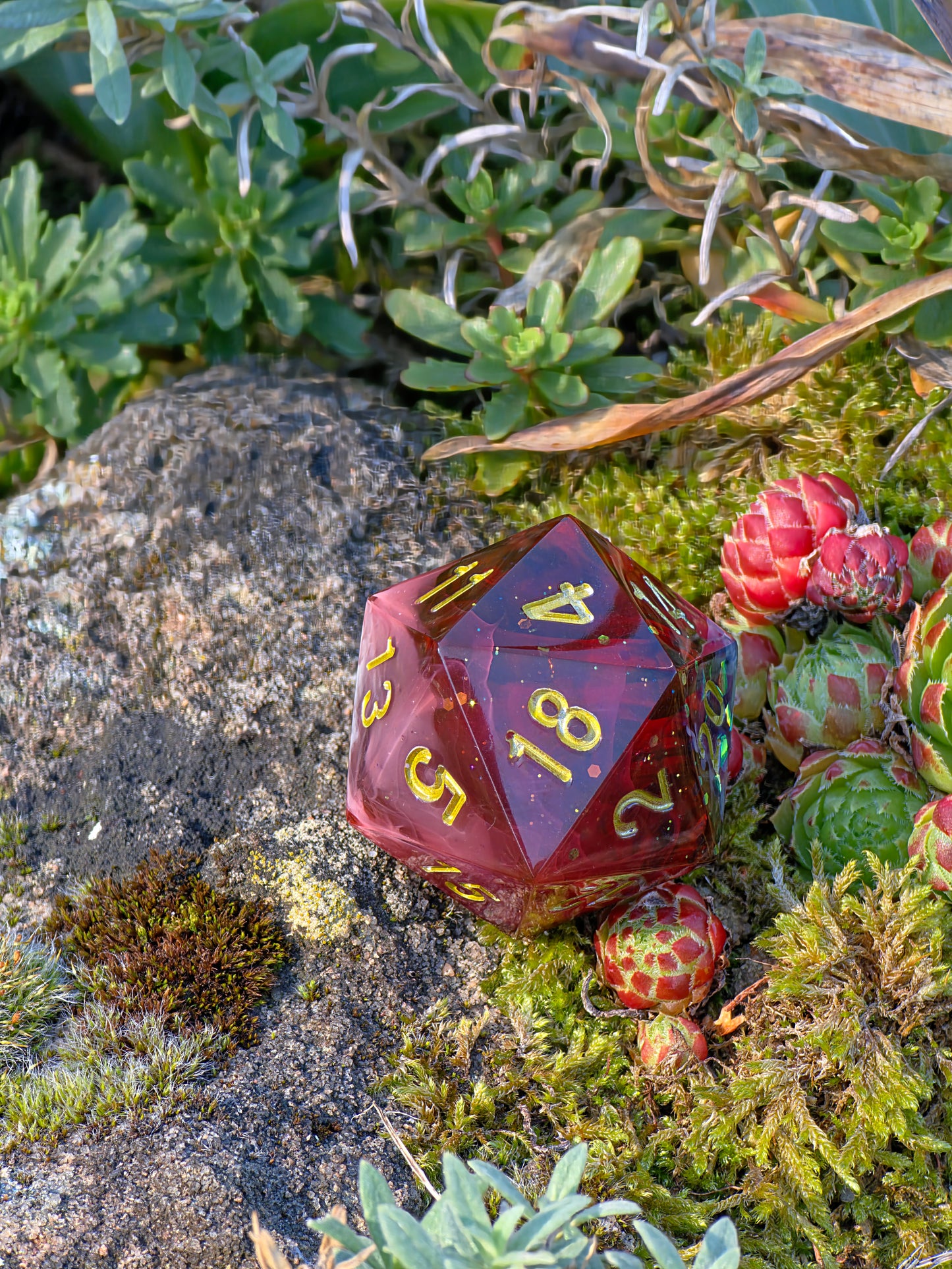 „Blood Mist“ in der Hand – intensives Blutrot mit goldener Gravur und transparenten Highlights.  
“Blood Mist” held in hand – intense blood red with golden engraving and transparent highlights.
