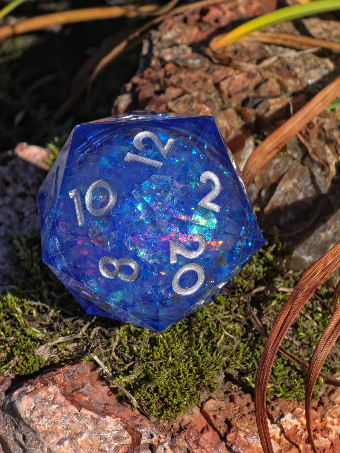 Handgemachter XL D20 „Blue Opal Liquid Core“ – blauer Würfel mit Flüssigkern und Opaleffekt.  
Handmade XL D20 “Blue Opal Liquid Core” – blue resin die with liquid core and opal effect.