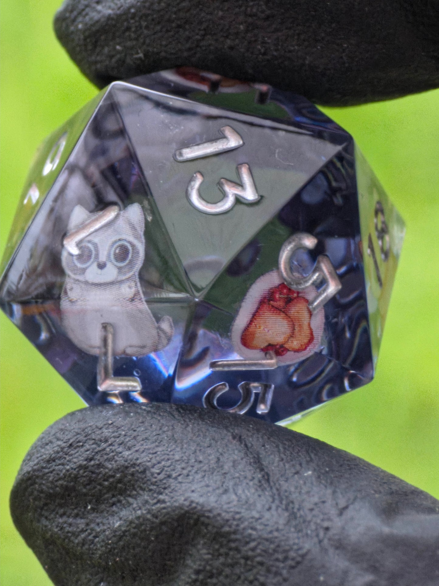 Detailaufnahme des „Cookie Cats“ Würfels – kleine Katzenfigur und glitzernde Akzente im Inneren.  
Close-up of the “Cookie Cats” die – tiny cat figure and sparkling accents inside.