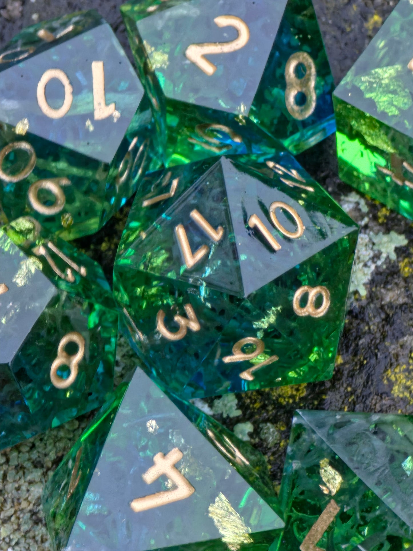 Resinwürfel „Emerald Grove“ auf grauem Hintergrund – zeigt Klarheit, Gravuren und smaragdgrüne Tiefe.  
“Emerald Grove” resin dice on gray background – showing clarity, engravings and deep emerald tones.