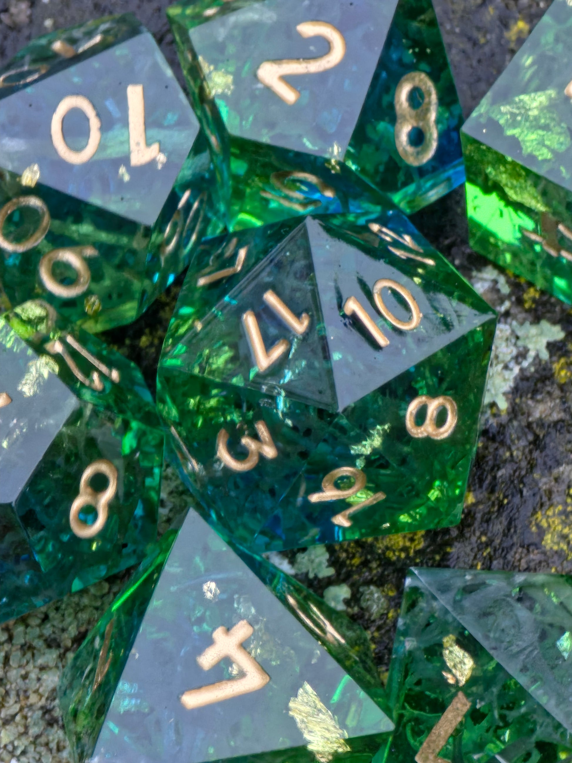 Resinwürfel „Emerald Grove“ auf grauem Hintergrund – zeigt Klarheit, Gravuren und smaragdgrüne Tiefe.  
“Emerald Grove” resin dice on gray background – showing clarity, engravings and deep emerald tones.