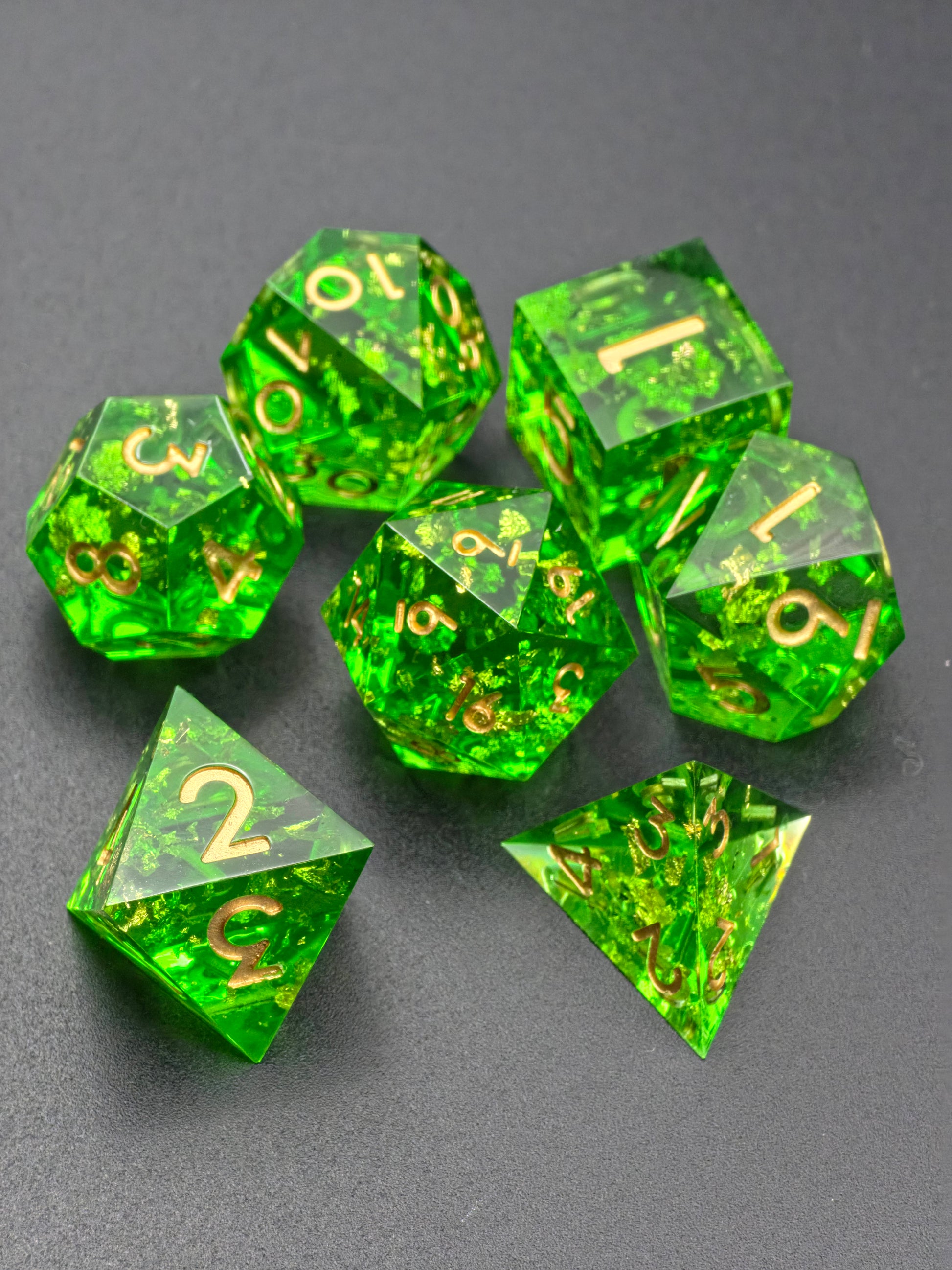 Detailaufnahme der „Emerald Treasure“ Würfel – goldene Flocken schimmern in transparentem Harz.  
Close-up of the “Emerald Treasure” dice – gold flakes sparkle inside clear resin.