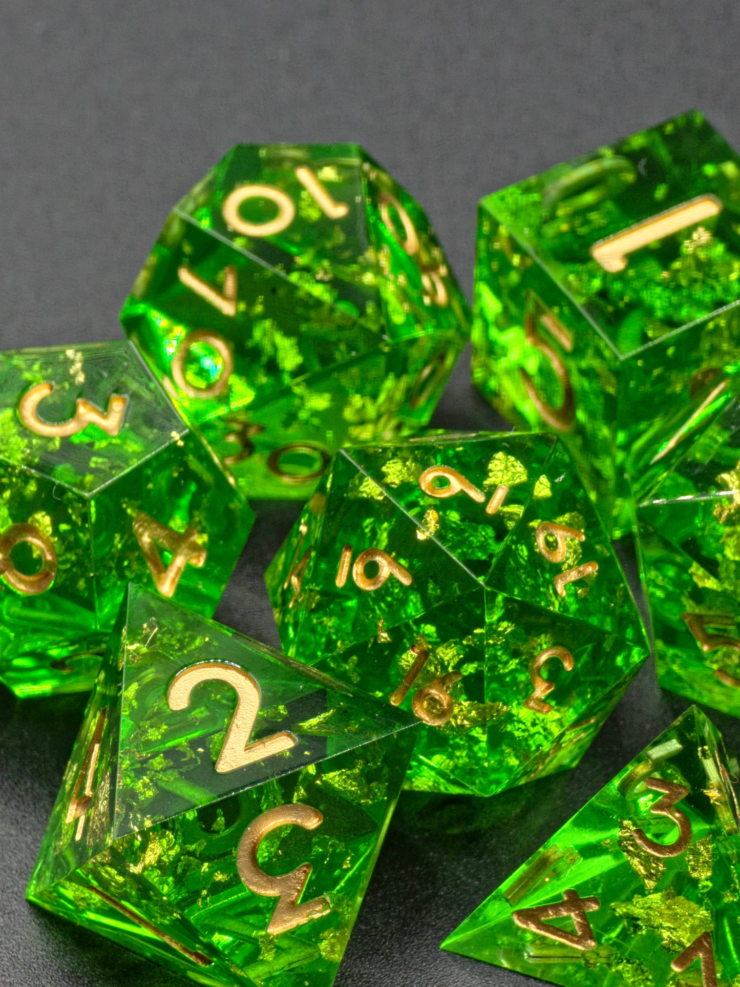 Handgemachtes polyedrisches Würfelset „Emerald Treasure“ aus smaragdgrünem Resin mit goldenen Flocken – inspiriert von Edelsteinen.  
Handmade polyhedral dice set “Emerald Treasure” in emerald-green resin with golden flakes – inspired by precious gems.