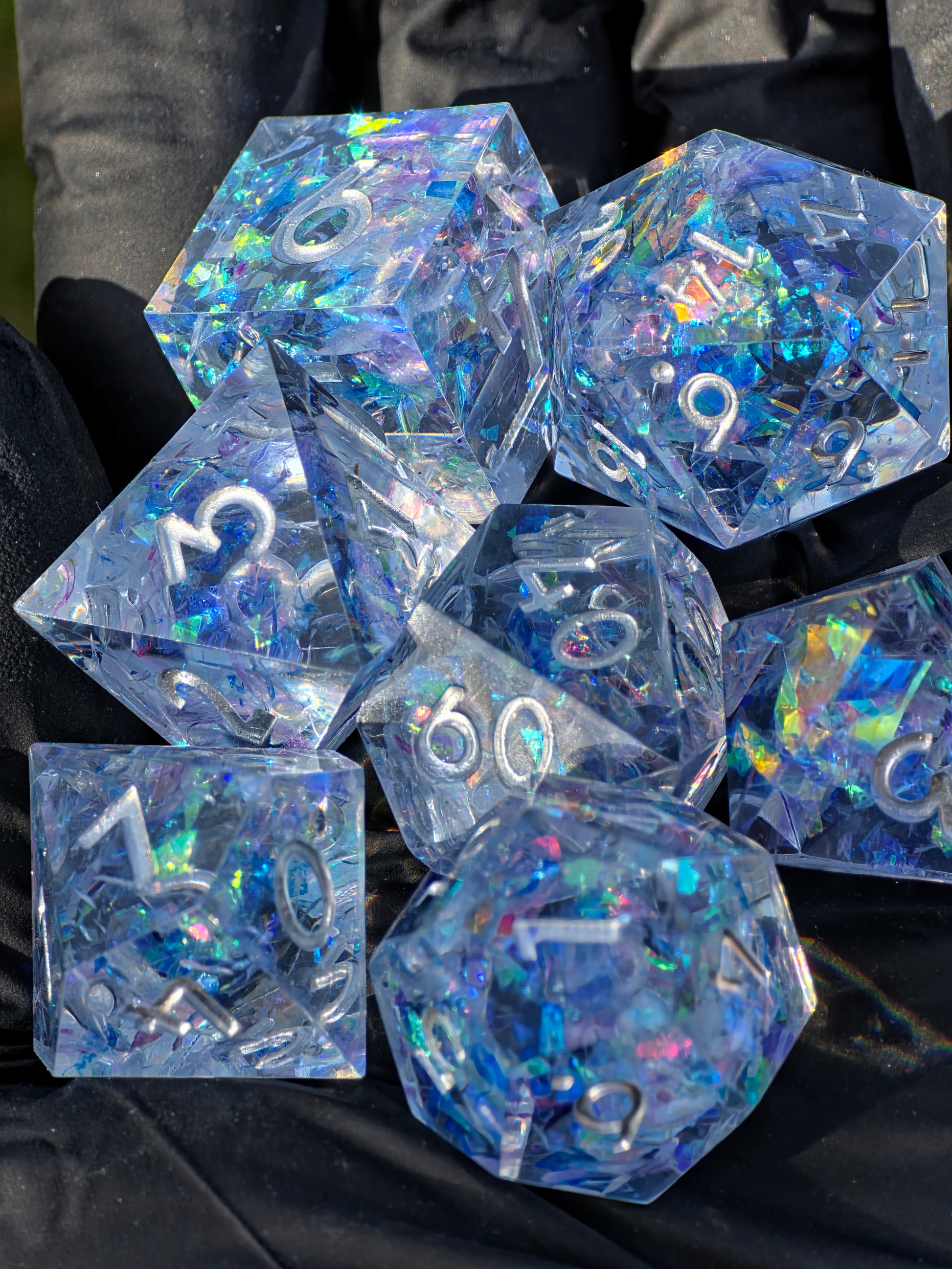 Handgemachtes polyedrisches Würfelset „Frozen Aurora“ aus klarem Resin mit eisblauem Opal-Effekt – inspiriert vom gefrorenen Nordlicht.  
Handmade polyhedral dice set “Frozen Aurora” in clear resin with icy blue opal effect – inspired by the frozen northern lights.