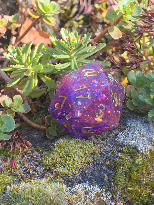 Handgemachter D20 „Galaxy Blossom“ – großer RPG-Würfel in Violett und Rosa mit goldenem Schimmer.  
Handmade D20 “Galaxy Blossom” – large RPG die in violet and pink with golden shimmer.