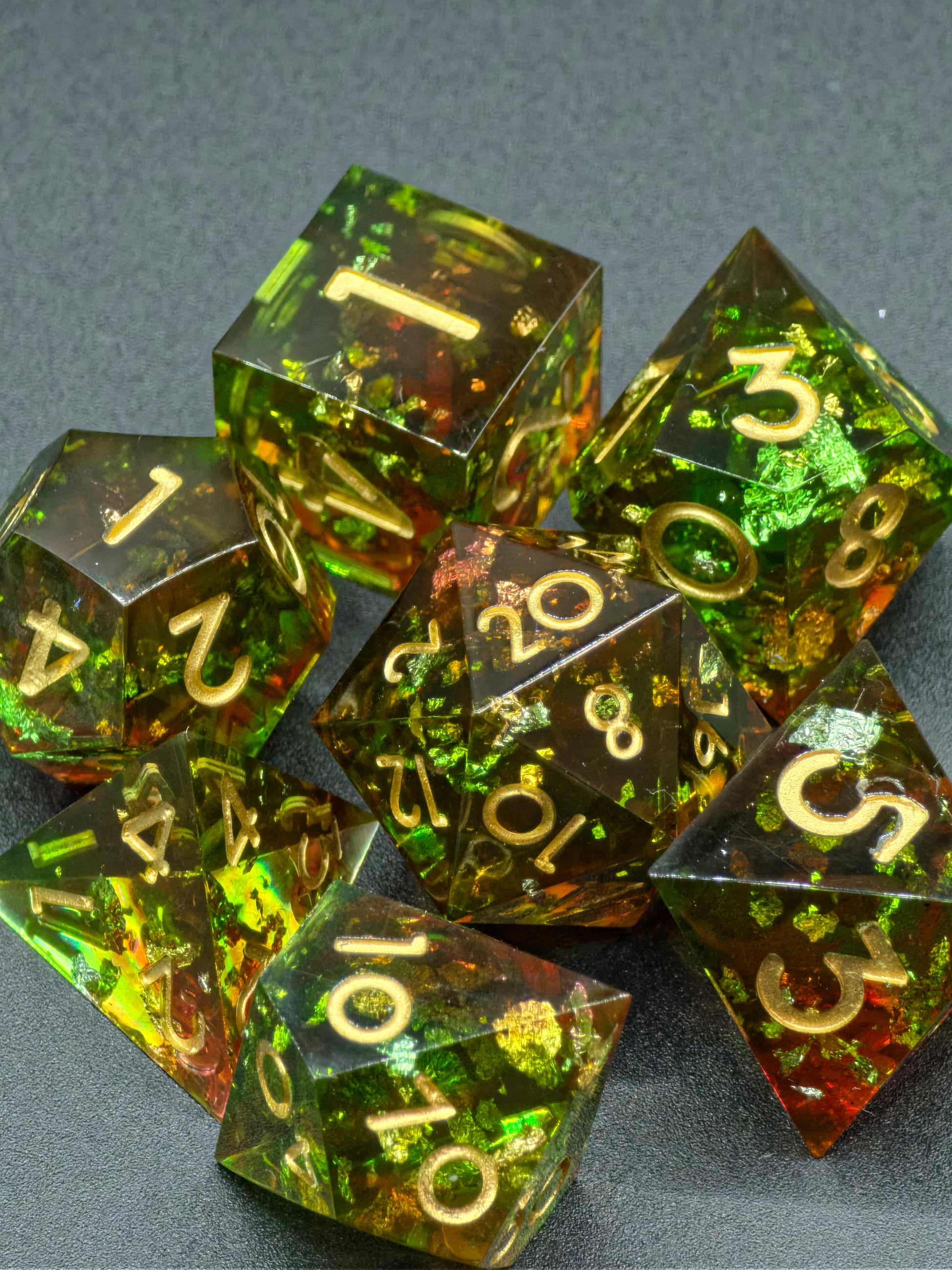 Handgemachtes polyedrisches Würfelset „Heart of the Forest“ aus Resin in Rot-Grün mit goldenen Flocken – inspiriert vom Zauber des Waldes.  
Handmade polyhedral dice set “Heart of the Forest” in red-green resin with golden flakes – inspired by the magic of the forest.