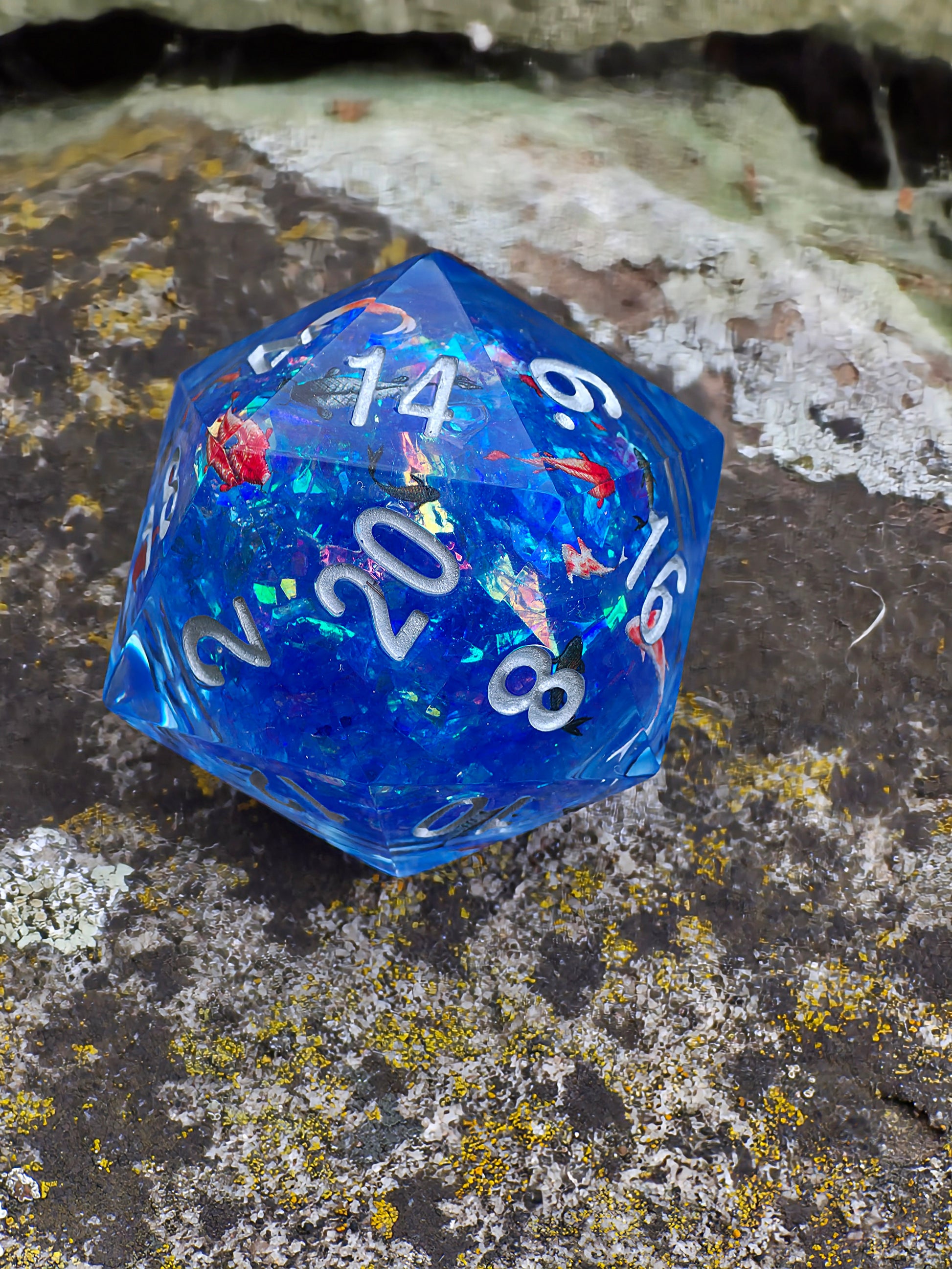 Studioaufnahme des „Koi Pond“ Liquid Core – klare Gravuren und glänzende Wasseroptik.  
Studio shot of the “Koi Pond” liquid core – clean engravings and glossy water-like appearance.