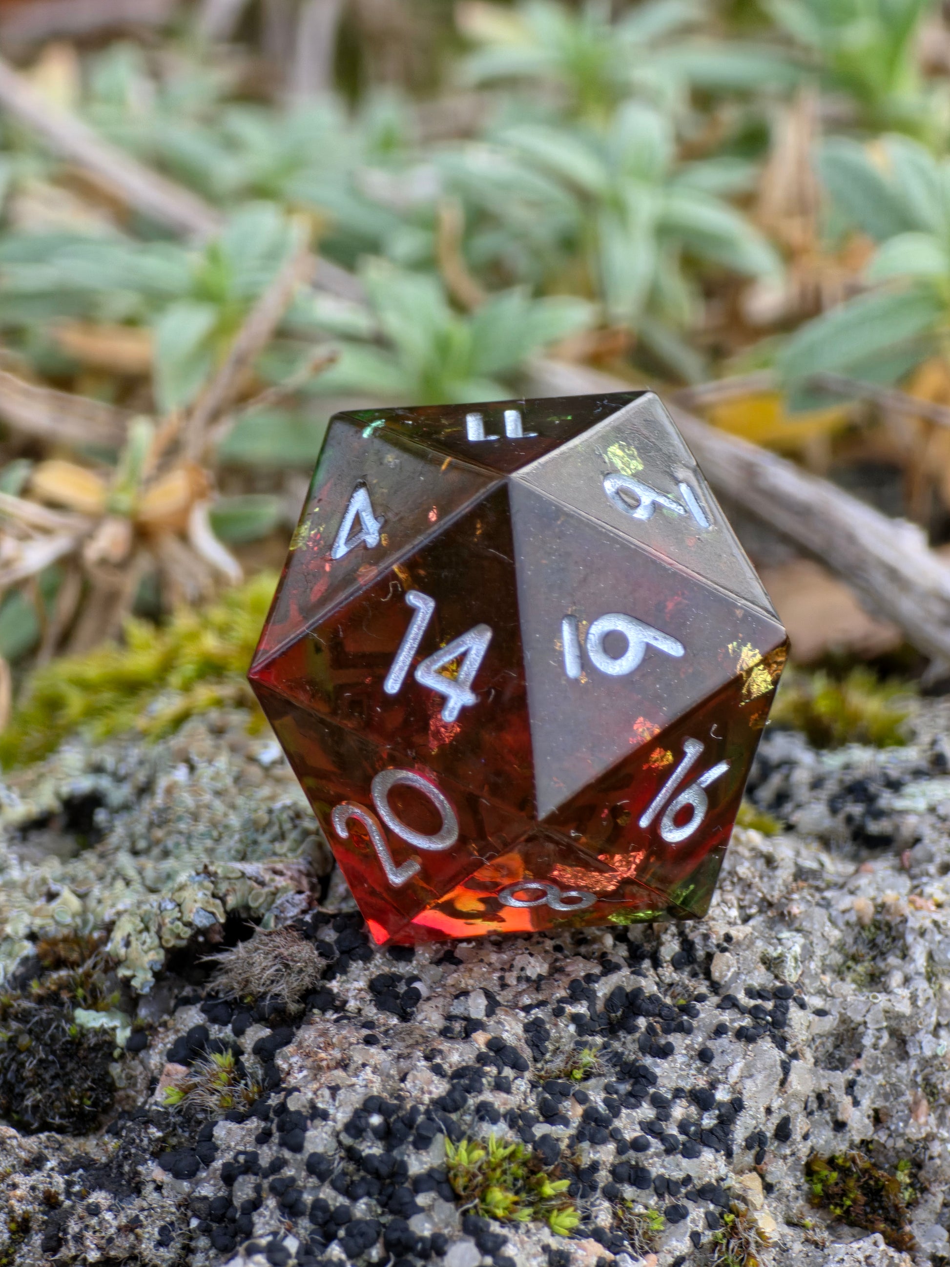 „Lava D20“ in der Hand – zeigt Tiefe, Transparenz und funkelnde Harzadern.  
“Lava D20” held in hand – showing depth, transparency and shimmering resin veins.