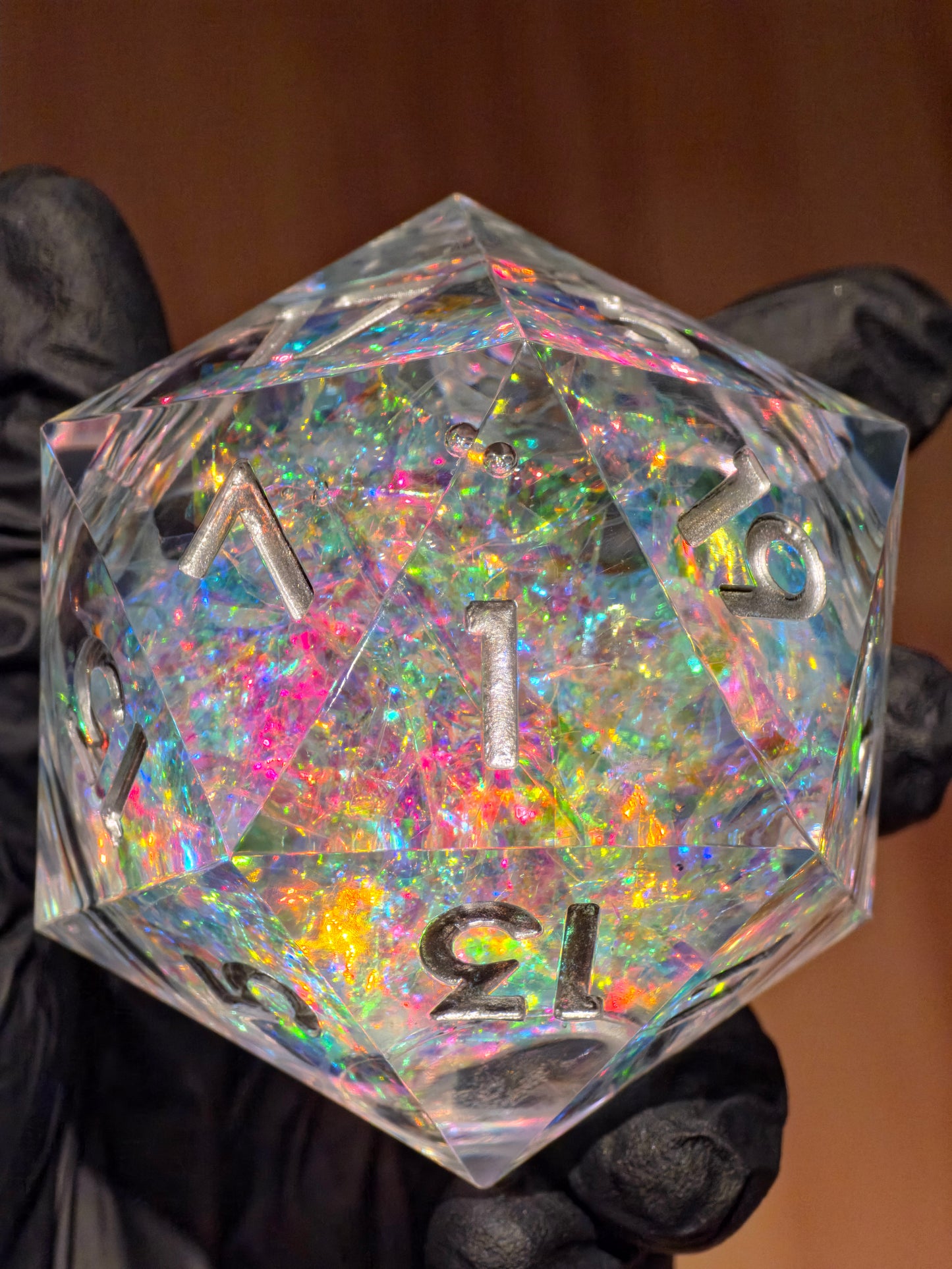 Detailaufnahme des „Liquid Core Opal Artefakt“ Würfels – das flüssige Zentrum reflektiert Regenbogenfarben im Licht.  
Close-up of the “Liquid Core Opal Artefact” die – the liquid core reflects rainbow hues under light.