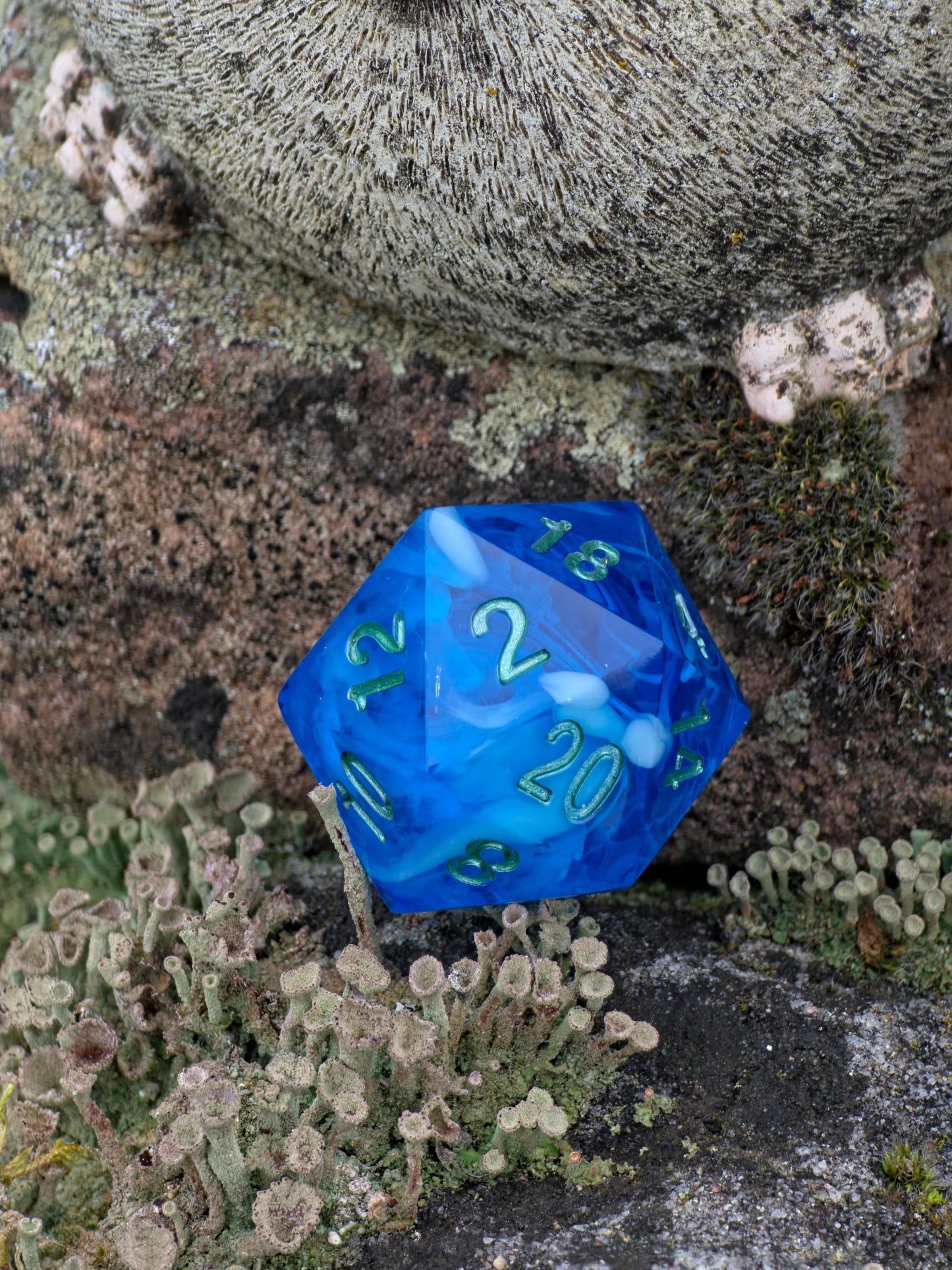 Detailaufnahme des „Ocean Blue Cloud“ Würfels – zeigt weiche Harzstrukturen und das Lichtspiel unter der Oberfläche.  
Close-up of the “Ocean Blue Cloud” die – showing soft resin swirls and light reflections beneath the surface.